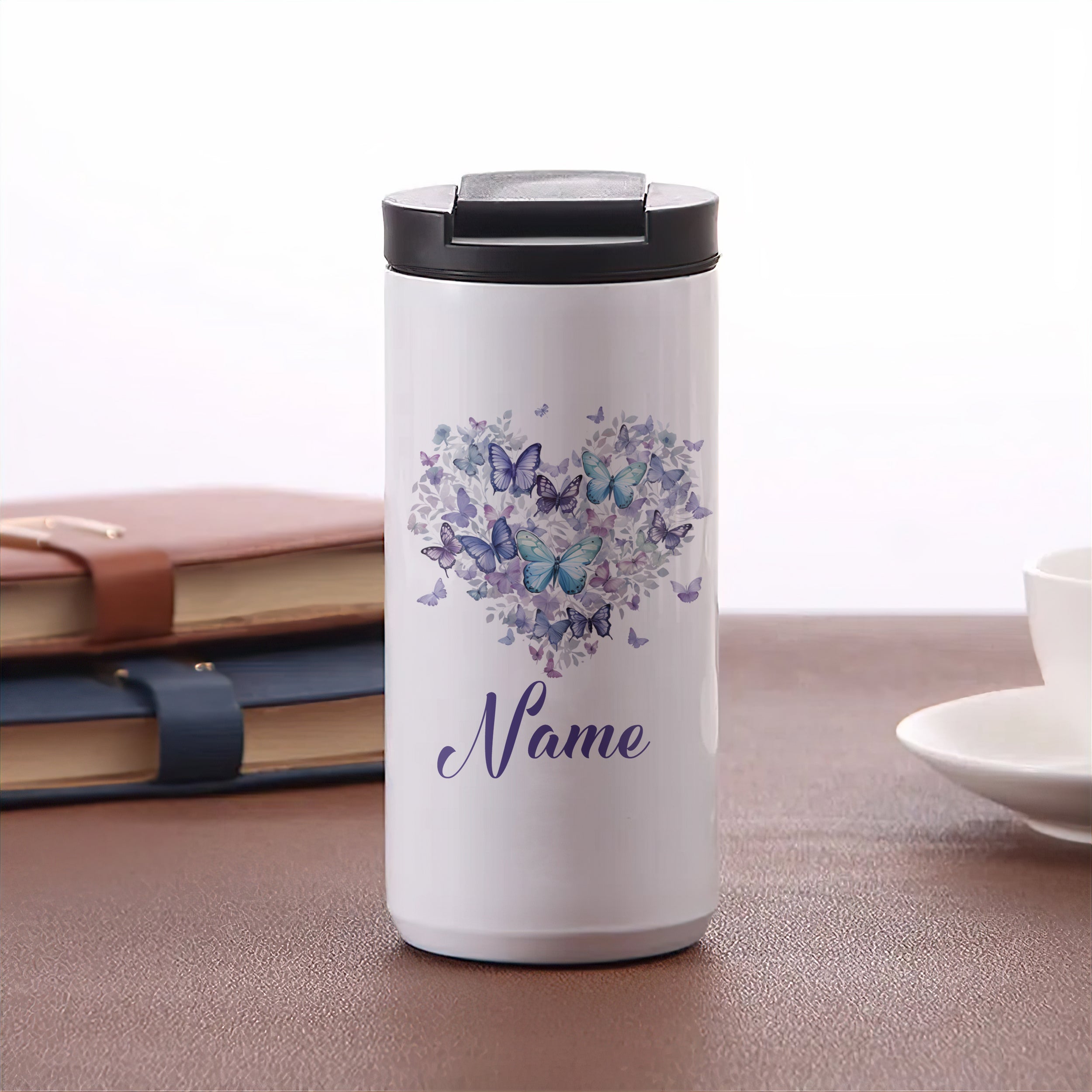 Weißer Thermobecher mit lila Schmetterlingen und personalisiertem Namen.