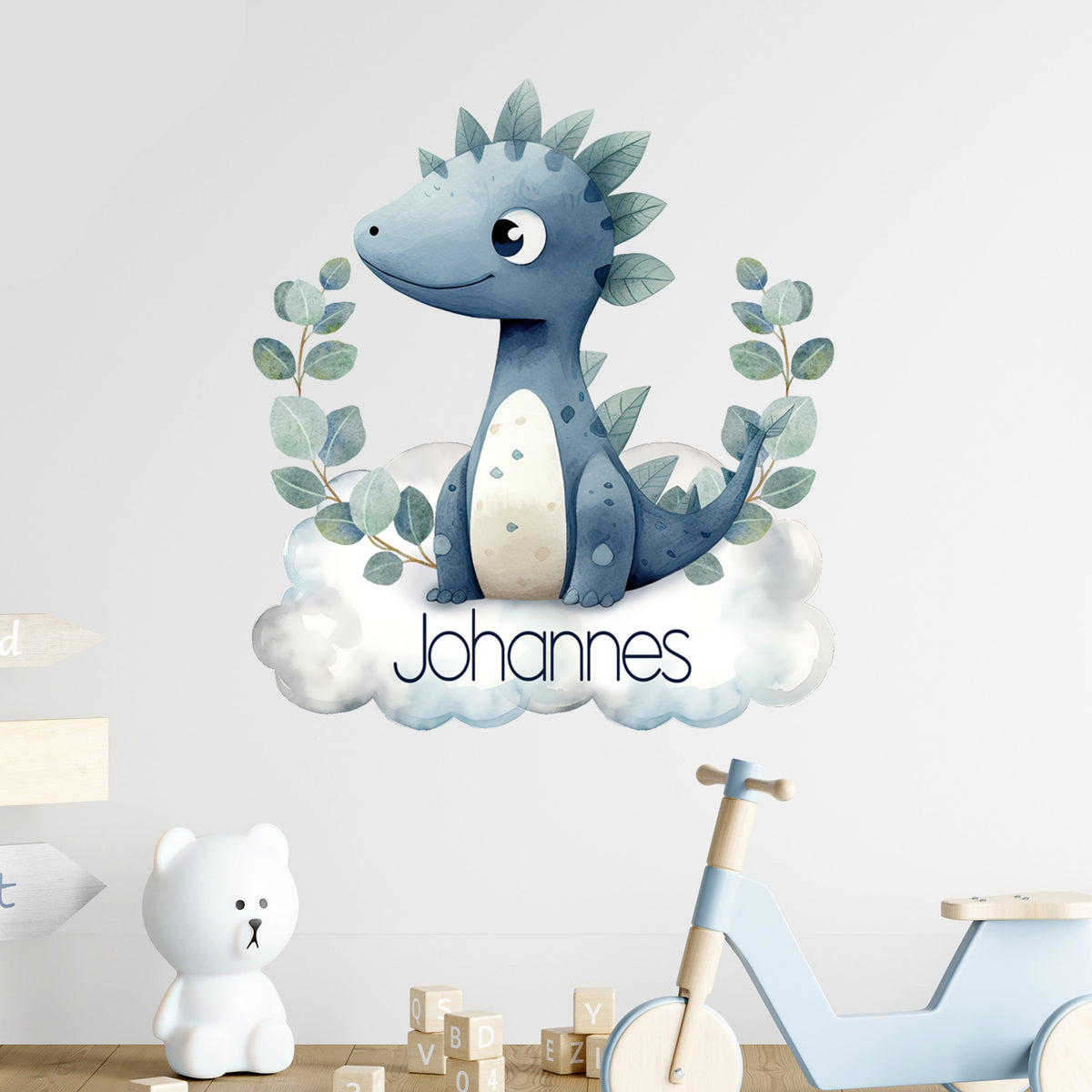 Wandtattoo mit blauem Dinosaurier auf Wolke und Wunschname an weißer Wand