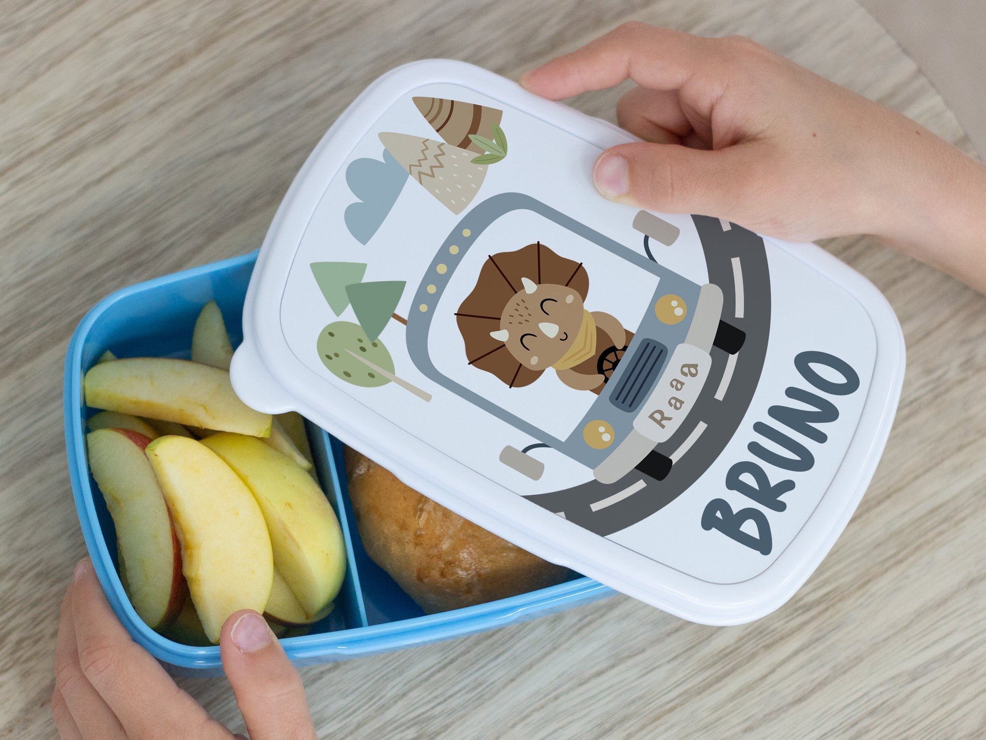 Bunte Brotdose mit Löwenmotiv und Obstfüllung.