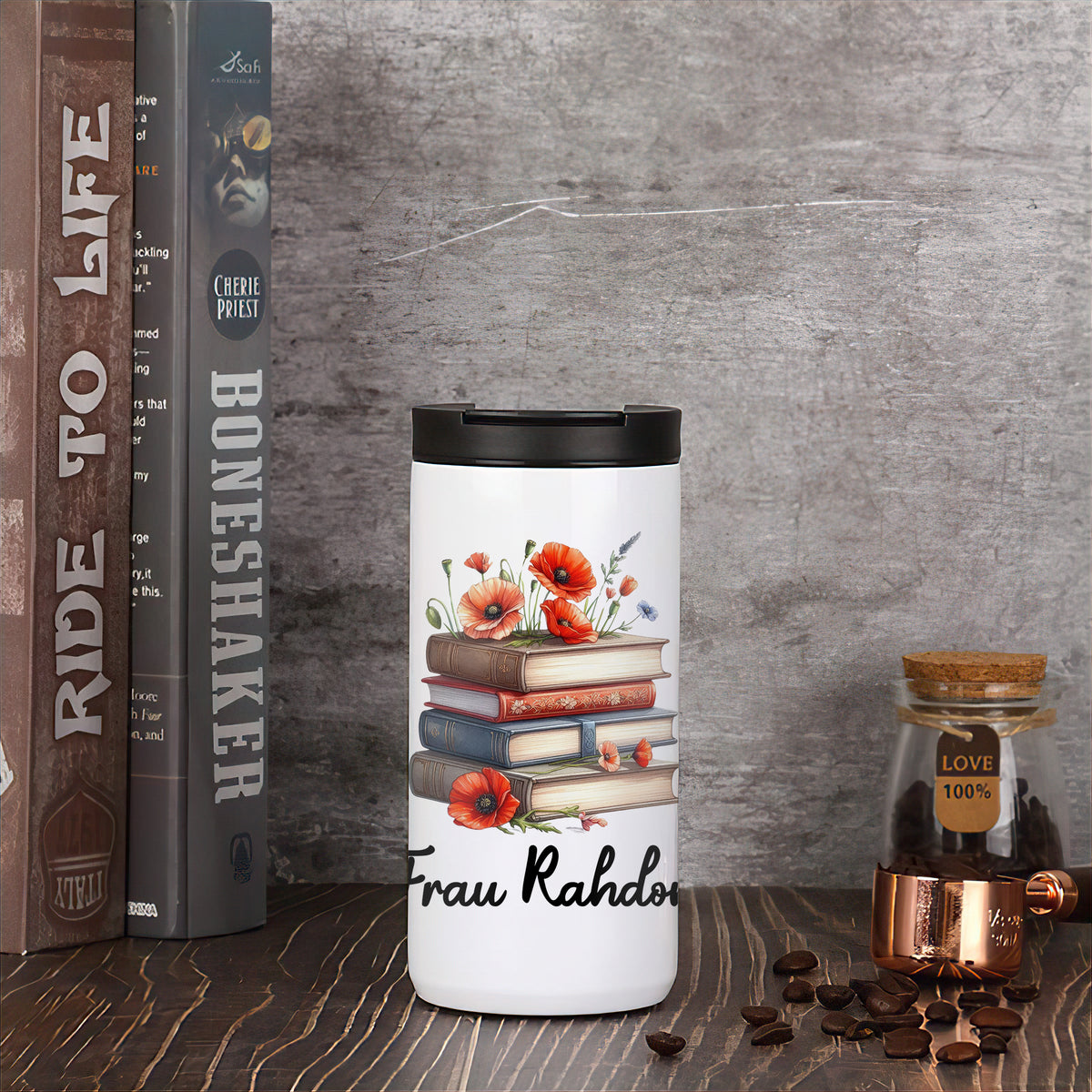 Thermo-Kaffeebecher mit Mohnblumen und Büchern in Wohnszene