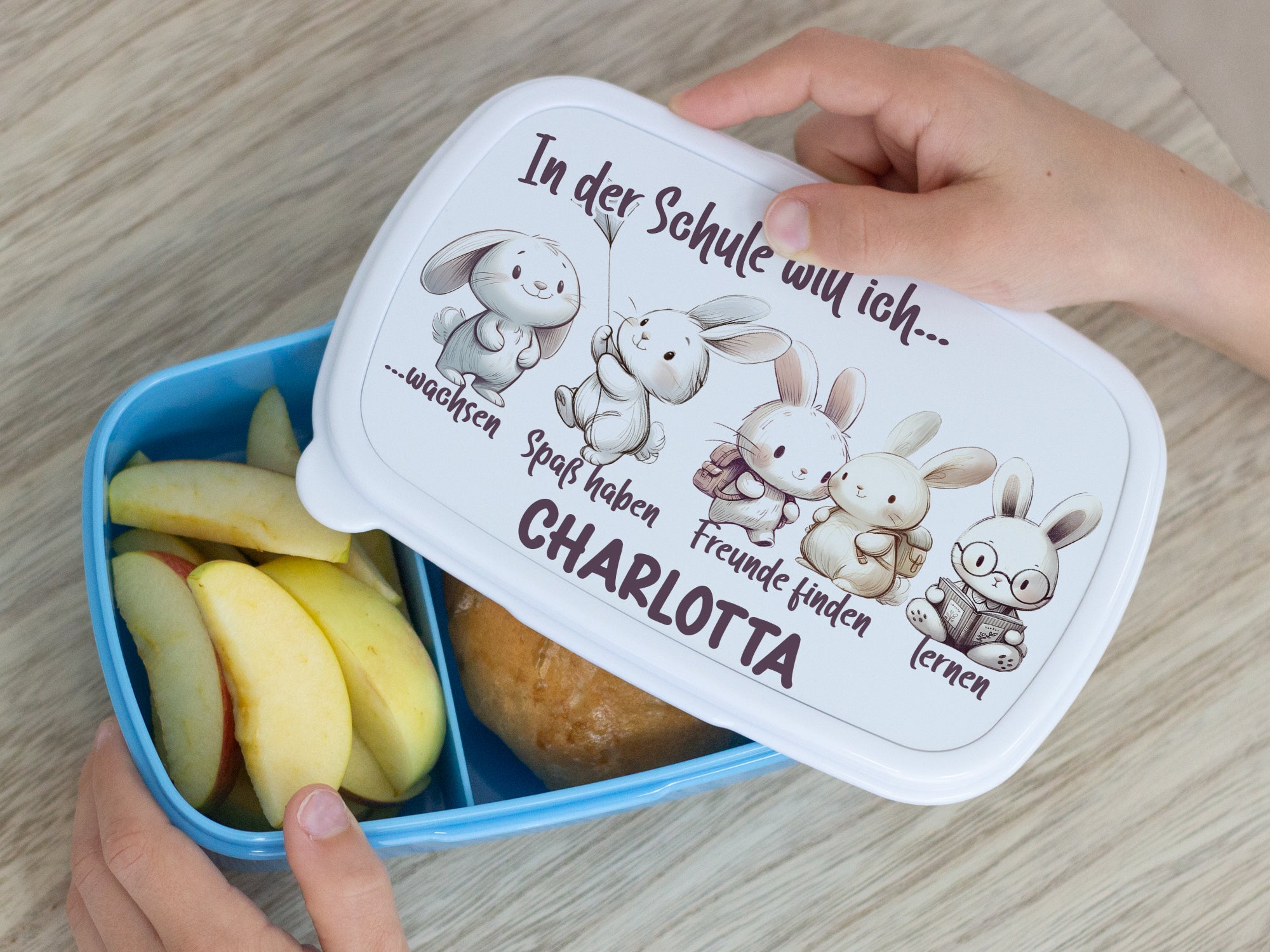 Bunte Brotdose mit Hasenmotiven und Namen Charlotta.