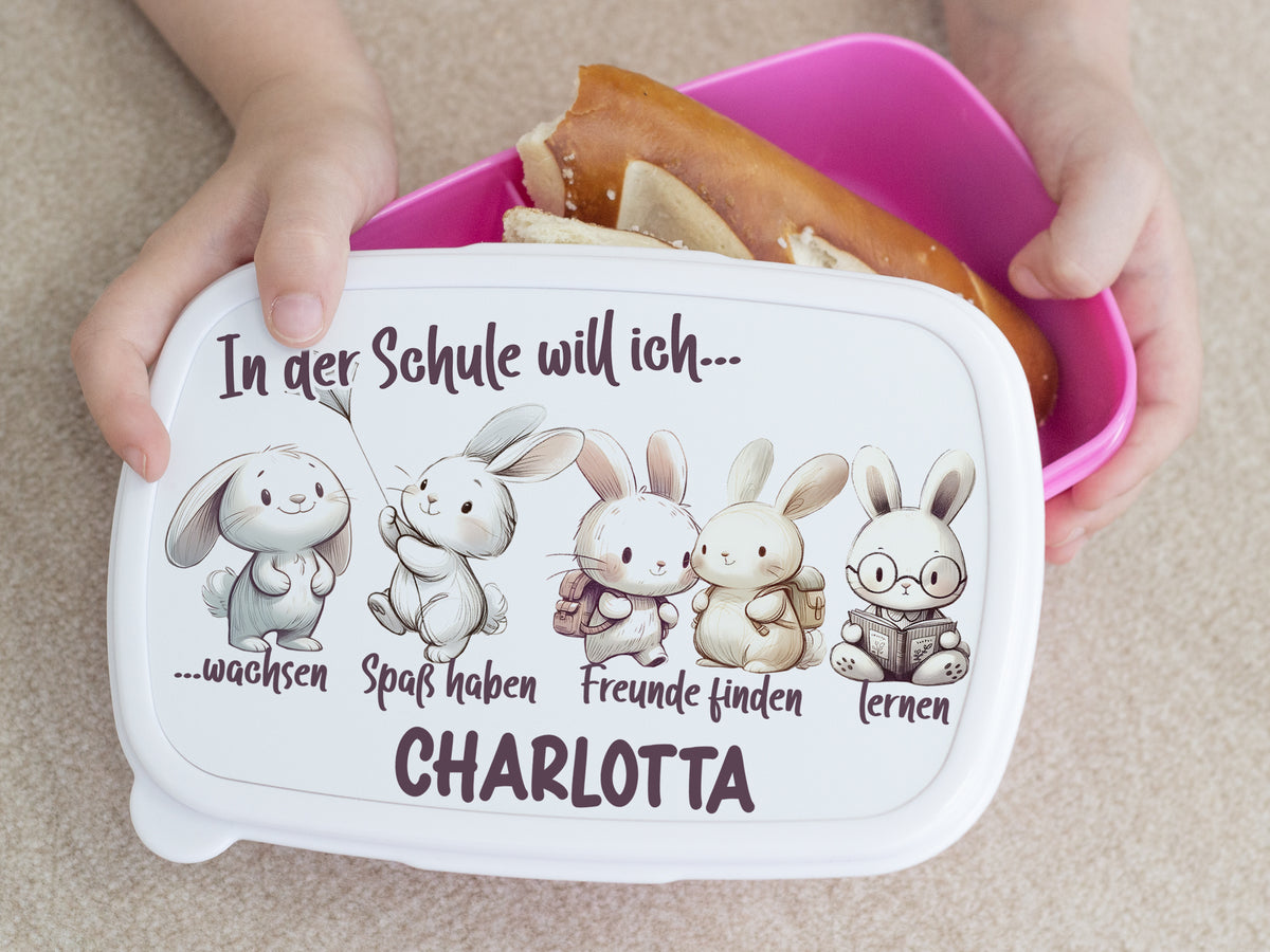 Bento-Box mit Hasenmotiven, weiß mit buntem Deckel.