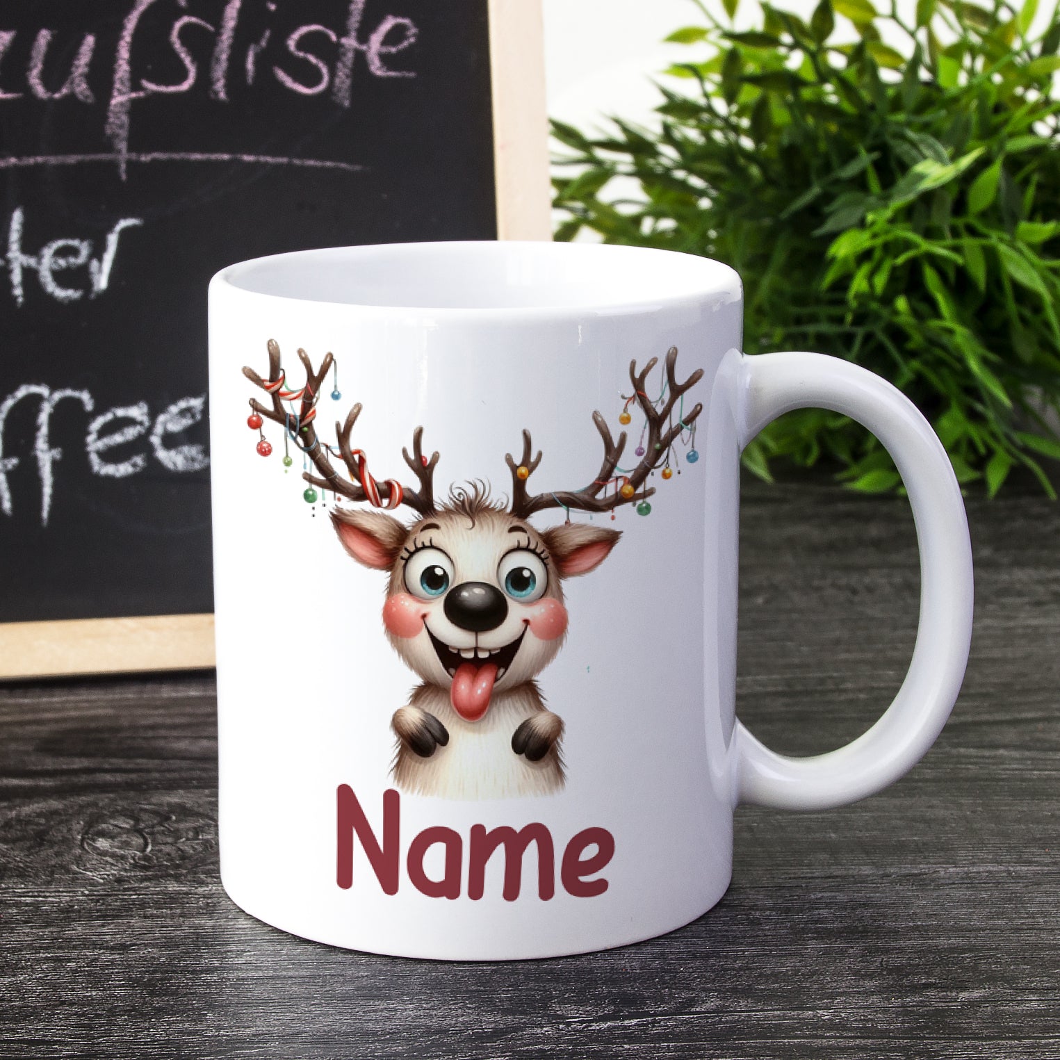 Weißer Becher mit Rentier-Motiv und rotem Schriftzug „Name“.