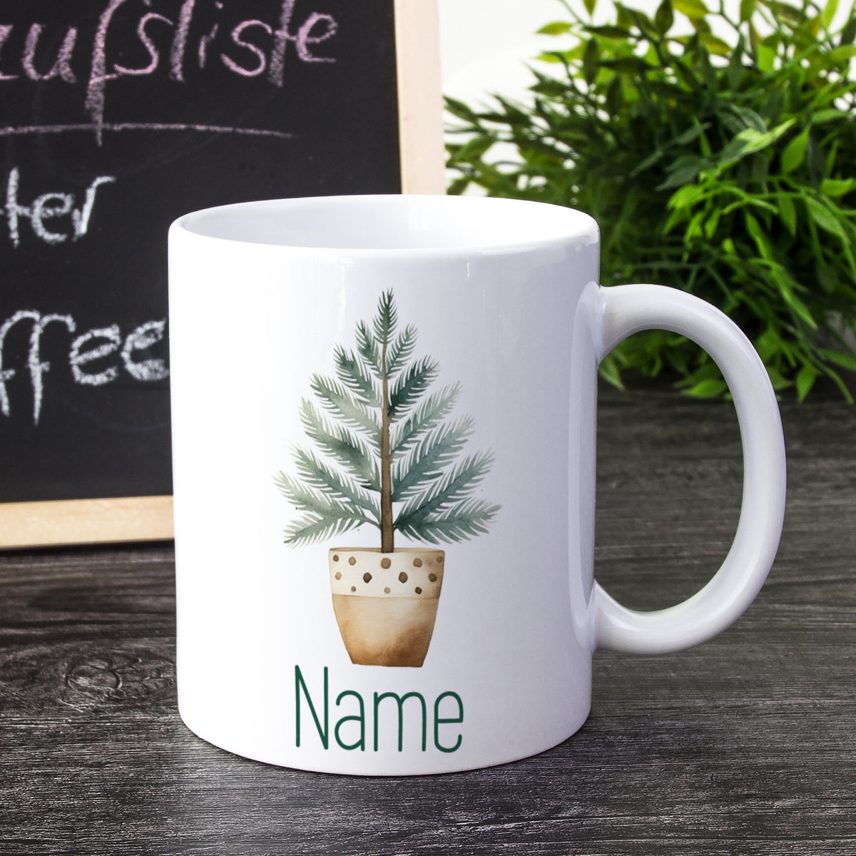 Weiße Tasse mit Pflanze und personalisiertem Namen.