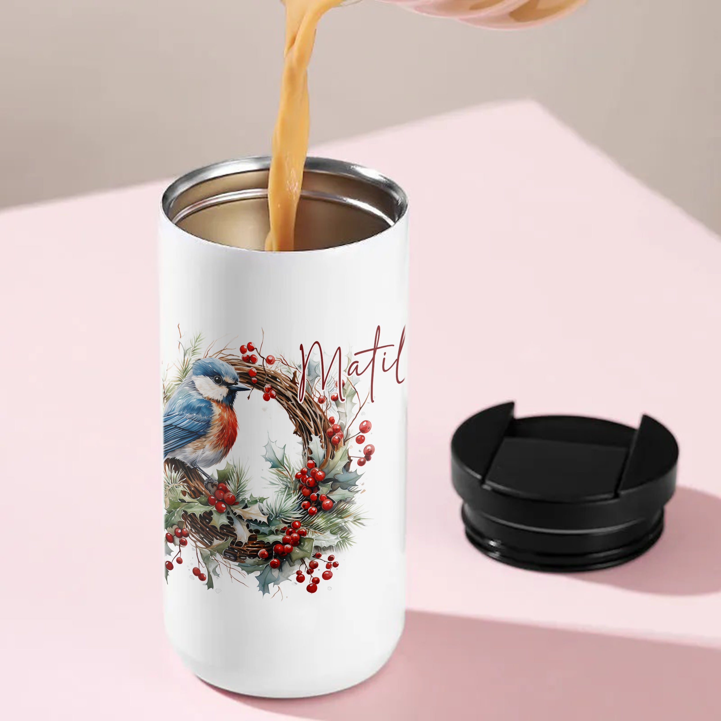 Weißer Becher mit Vogelmotiv und Weihnachtskranz.