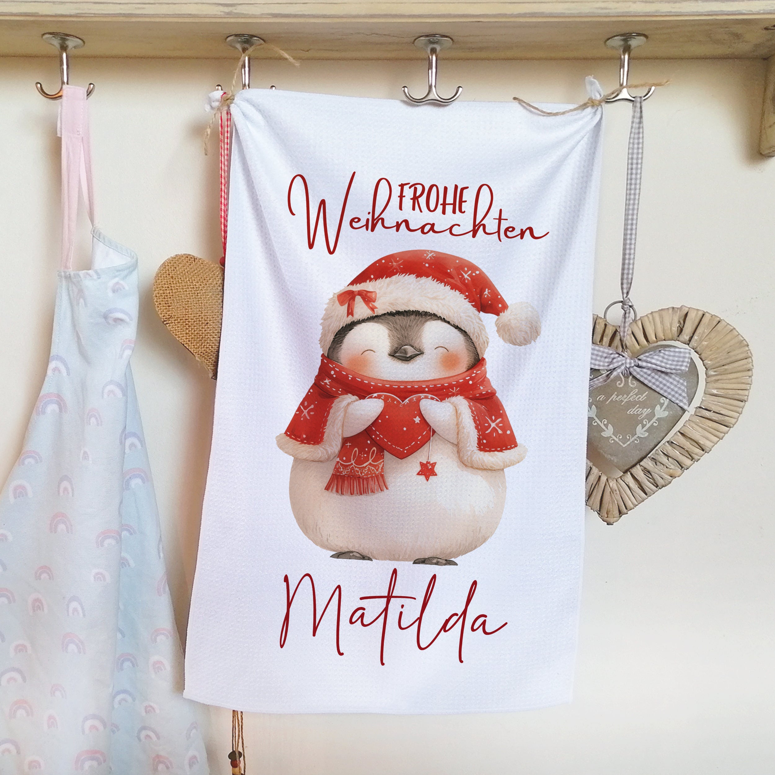 Frohe Weihnachten Handtuch mit Pinguin und rotem Schal.