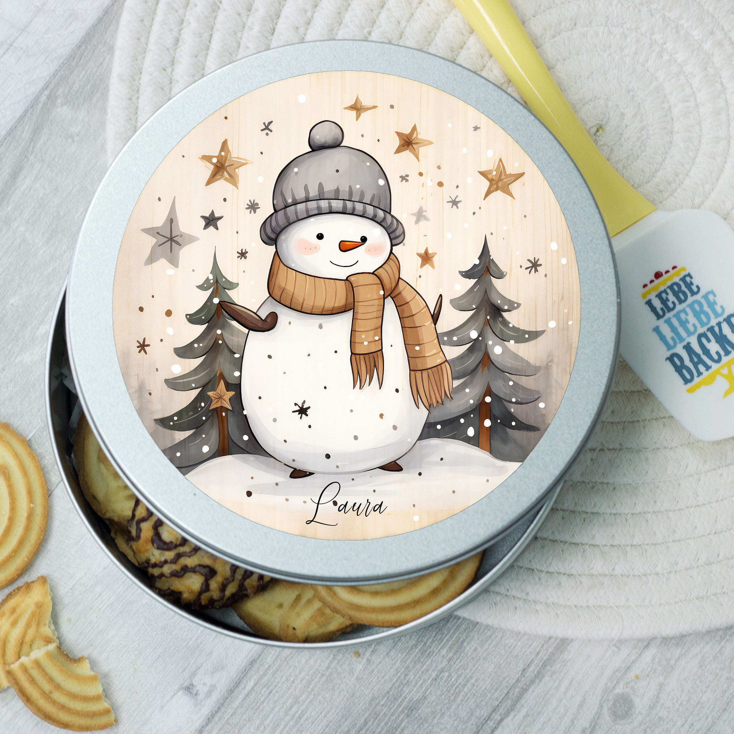 Kekse in runder, silberner Dose mit Schneemann-Motiv.