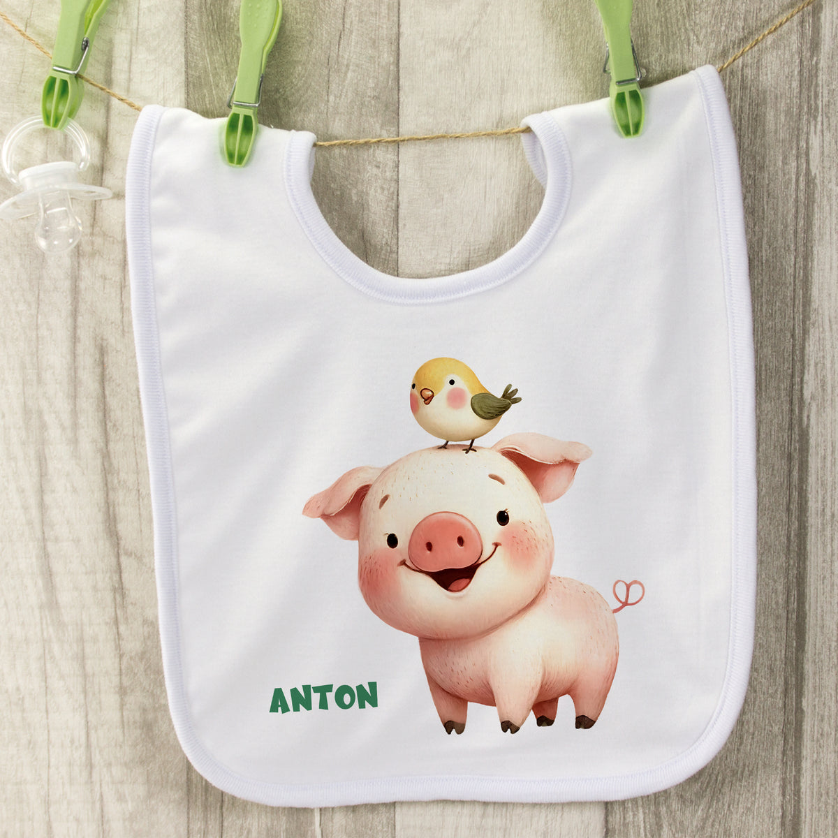 Weißes Lätzchen mit lustigem Schwein und Vogel, personalisiert mit "ANTON".