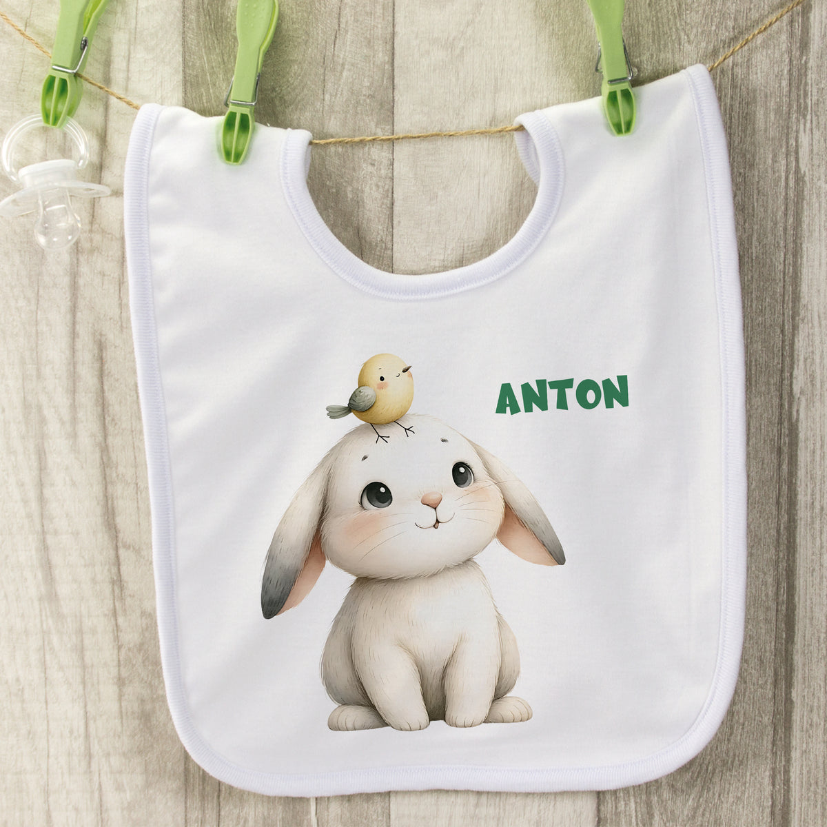 Weißes Lätzchen mit niedlichem Hasen und Vogel, Name Anton.