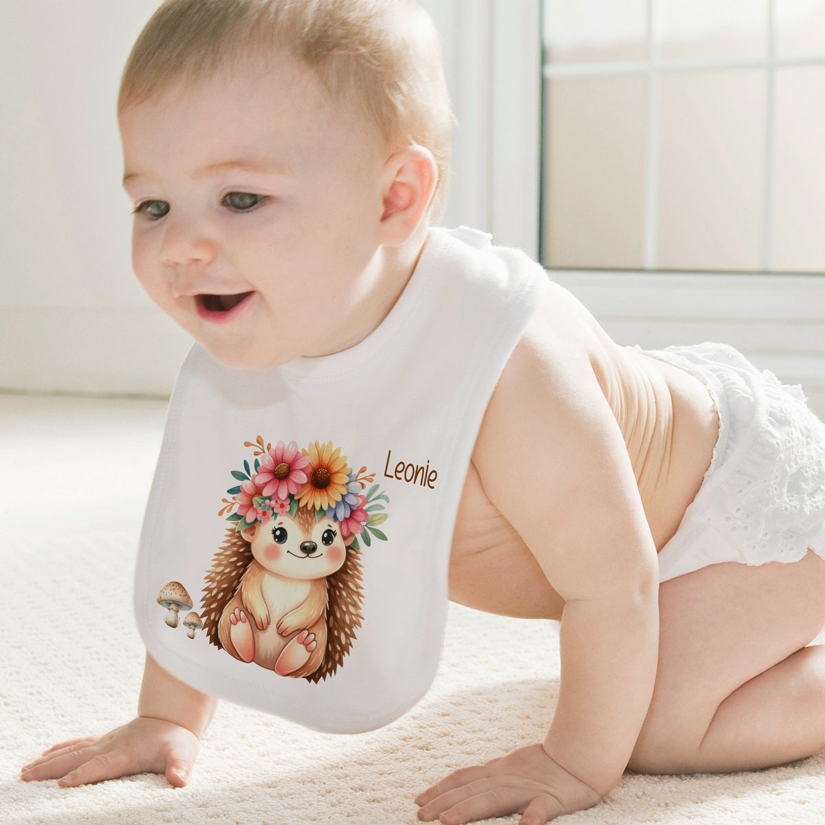 Lätzchen mit Igel-Motiv und Blumenkranz, personalisiert mit "Leonie".