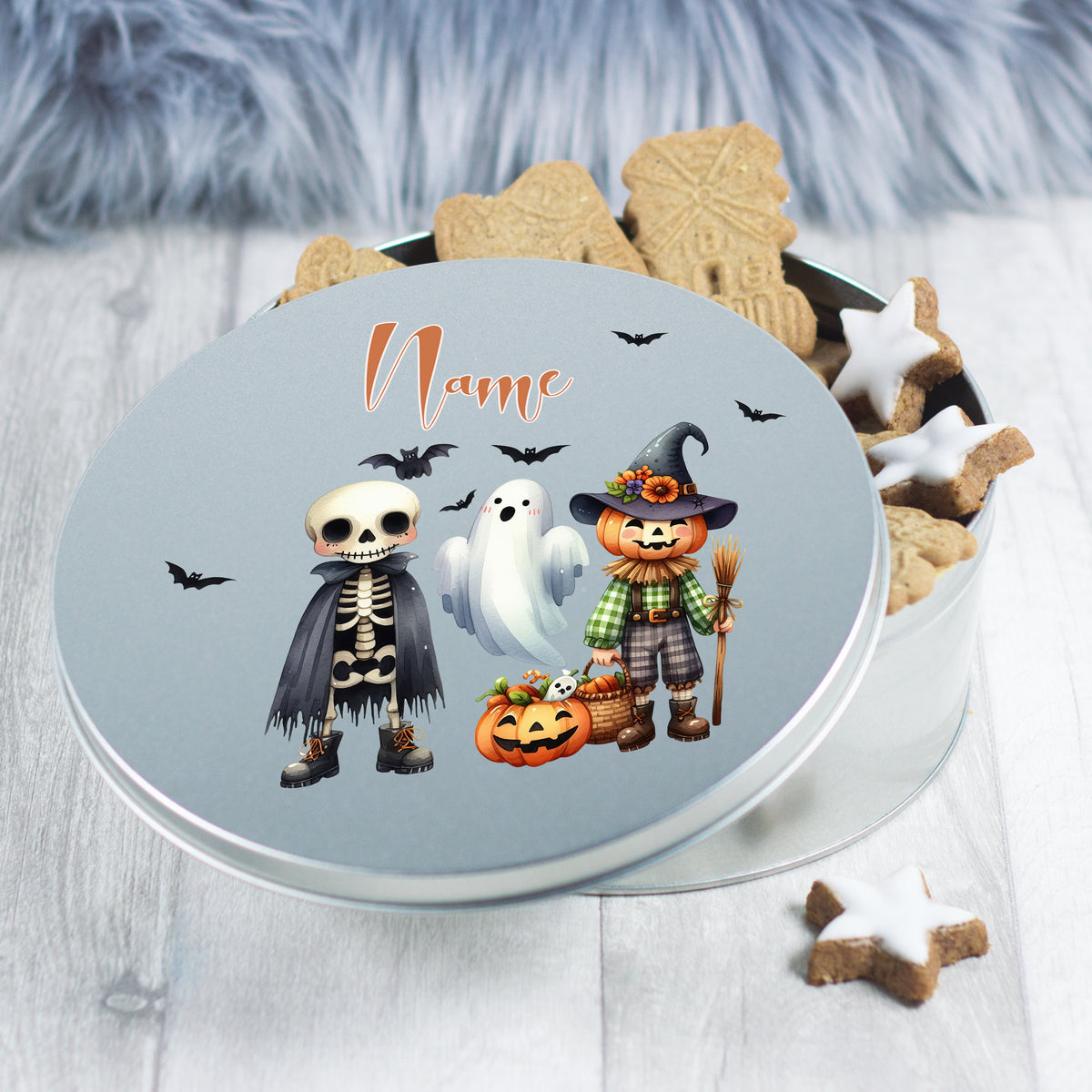 Blechdose mit Halloween-Motiven: Skelett, Geist, Kürbis, Hexenfigur.
