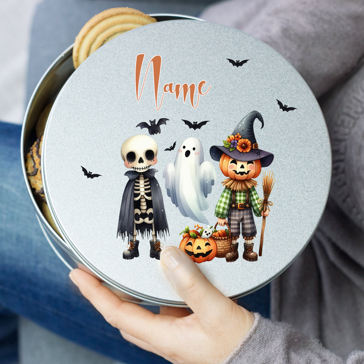 Bunte Halloween-Keksdose mit Skelett, Geist und Kürbis.