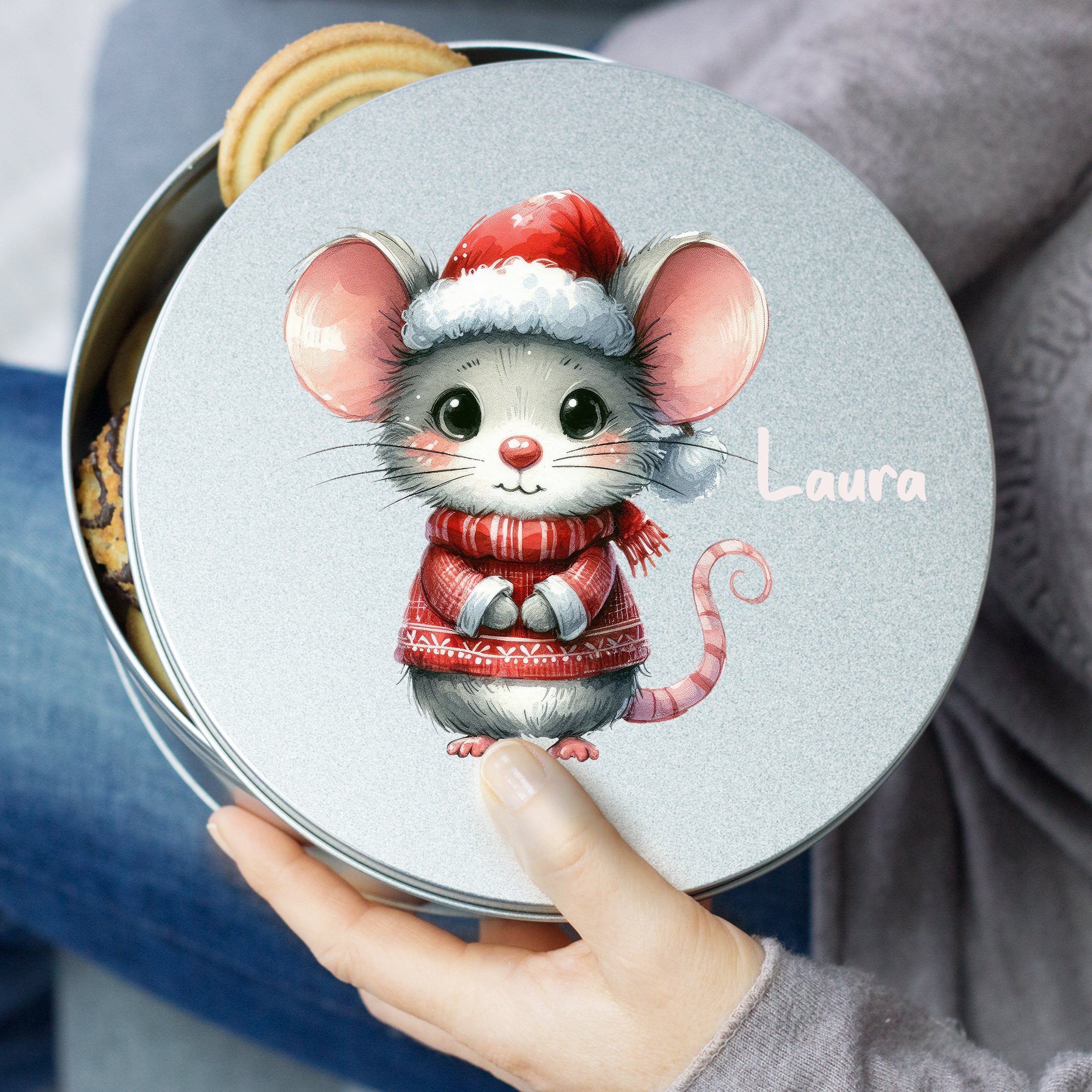 Keksdose mit niedlicher Maus in rotem Pullover und Weihnachtsmütze.