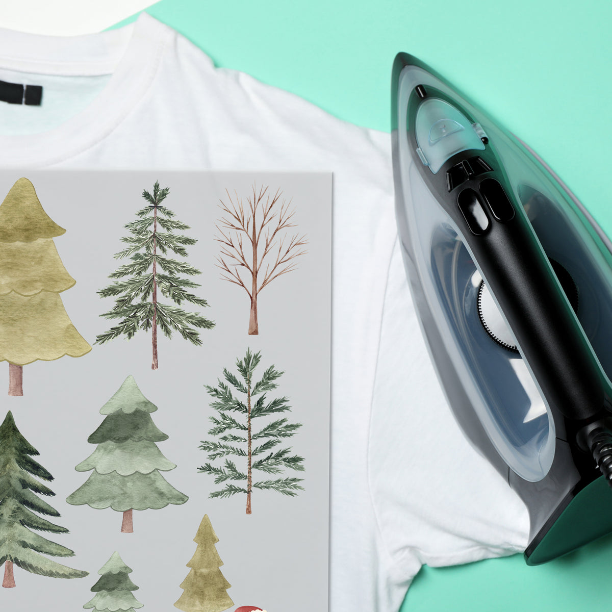 Weißes T-Shirt mit grünen Baum-Motiven und Dampfbügeleisen.
