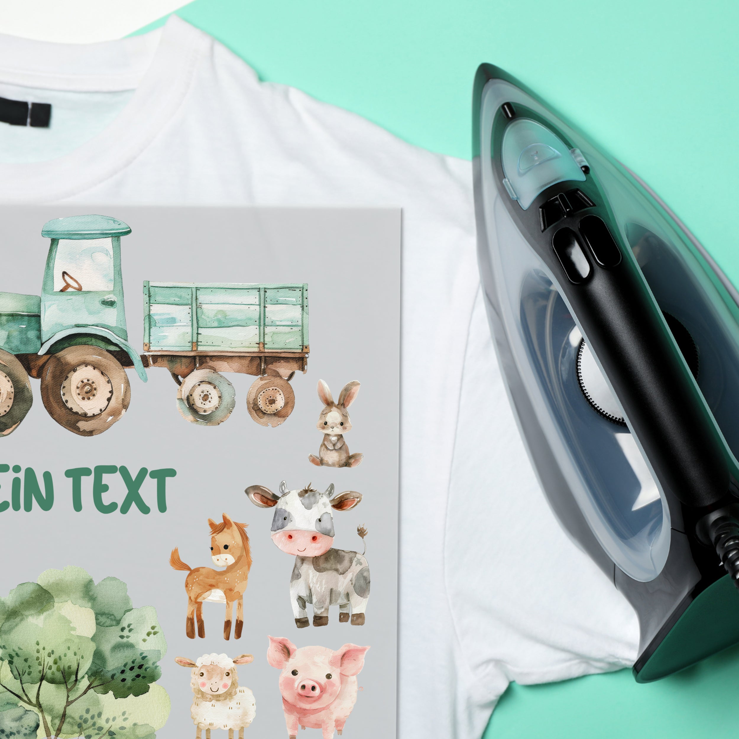 Weißes T-Shirt mit buntem Bauernhof-Motiv und Bügeleisen.