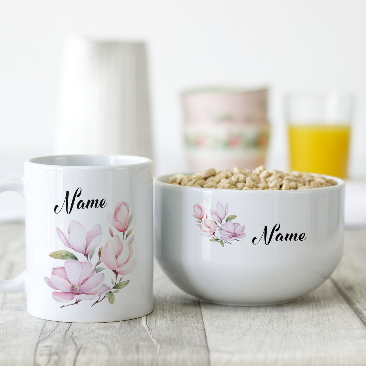 Weiße Tasse und Schüssel mit Magnolien-Muster und Namen.