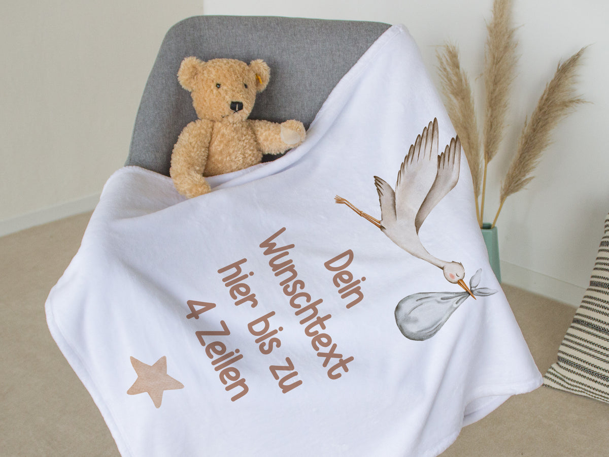 Weiße Decke mit personalisierbarem Text und Storch-Motiv.