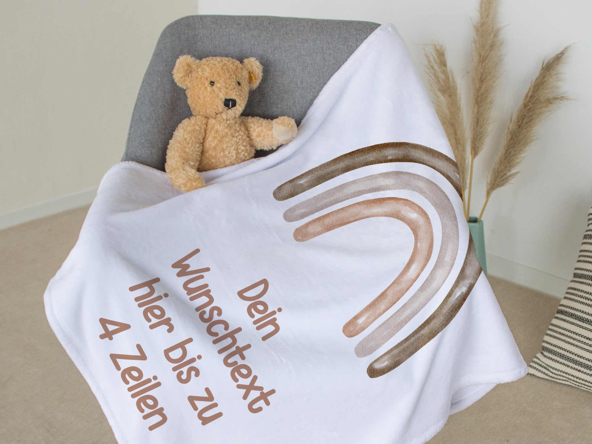 Weiße Decke mit personalisierbarem Text und Regenbogen-Motiv.