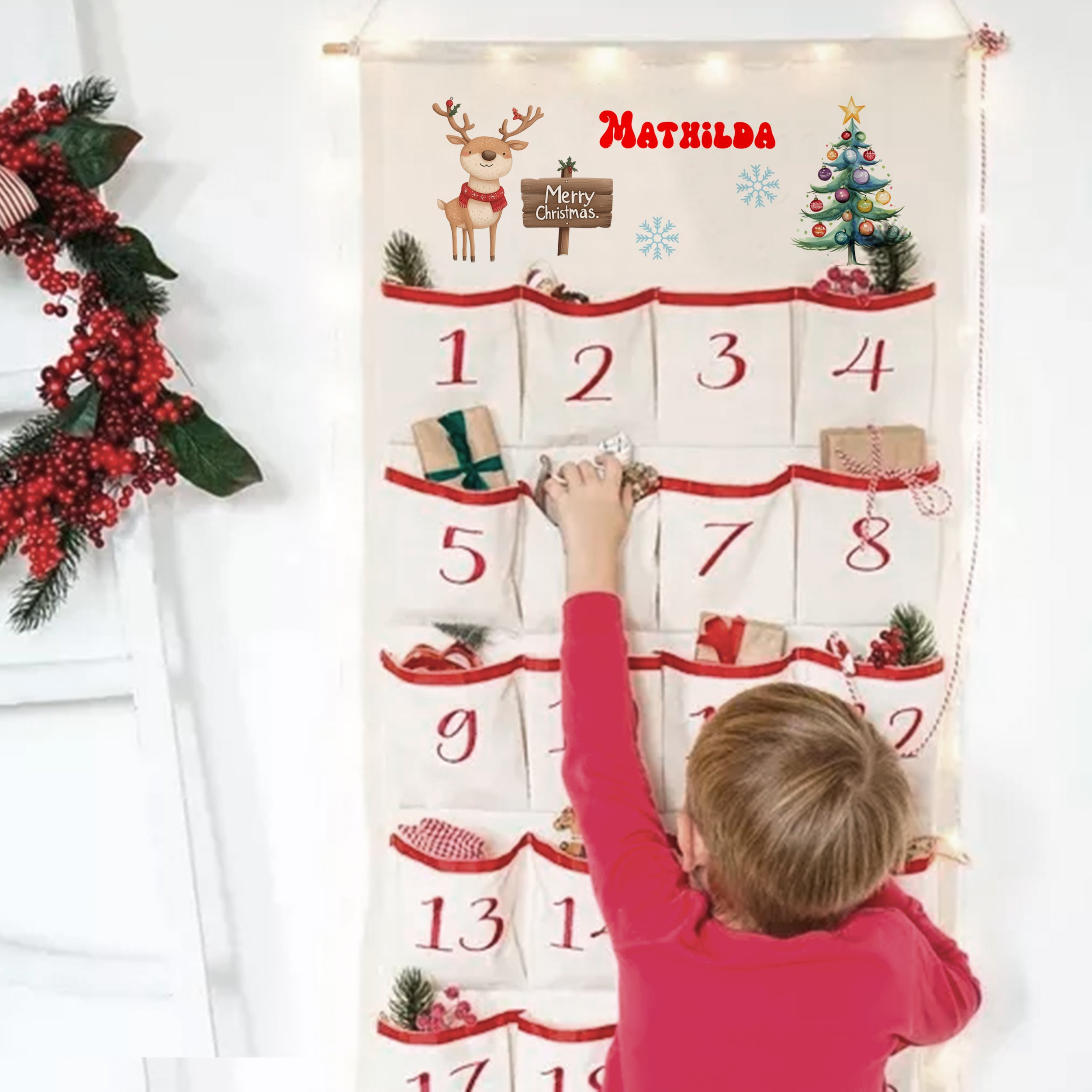 Adventskalender mit roten Details und Weihnachtsmotiven, Kind greift nach Geschenk.