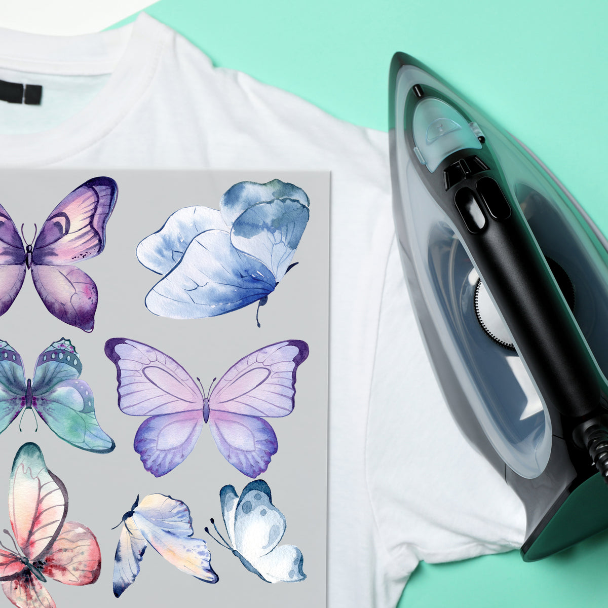 Weißes T-Shirt mit lila Schmetterlings-Druck und Dampfbügeleisen.