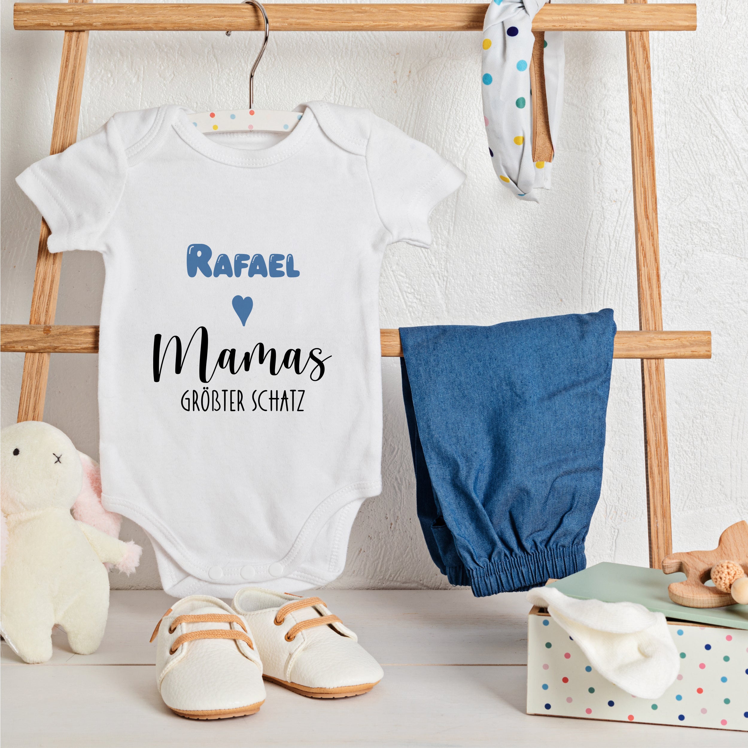 Weißes Babybody mit blauem Text, "Rafael Mamás größter Schatz".