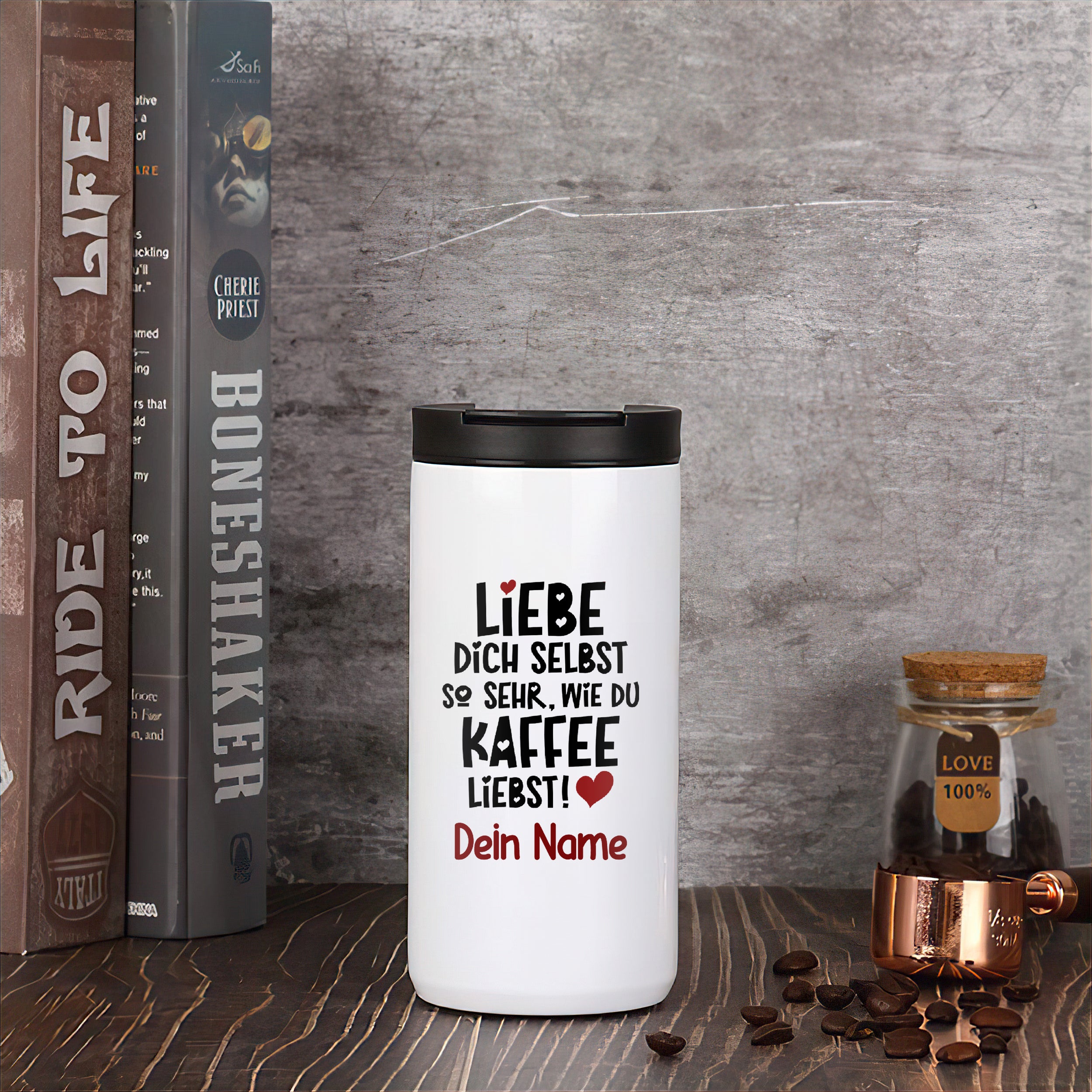 Weißer Kaffeebecher mit schwarzem Text und Herzmotiven.