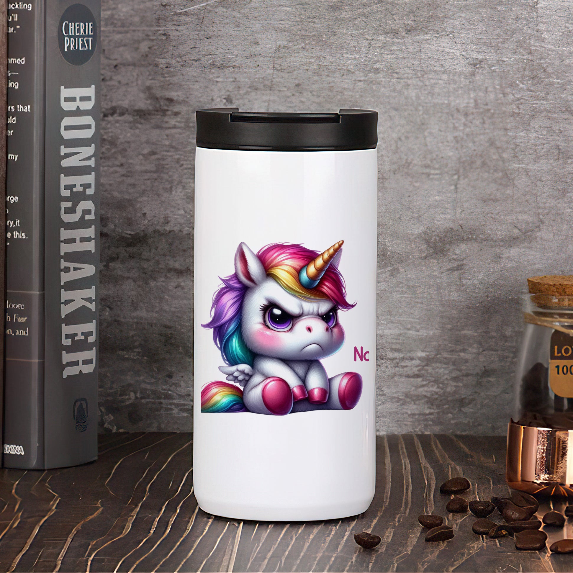 Weißer Becher mit buntem Einhorn-Motiv und schwarzem Deckel.