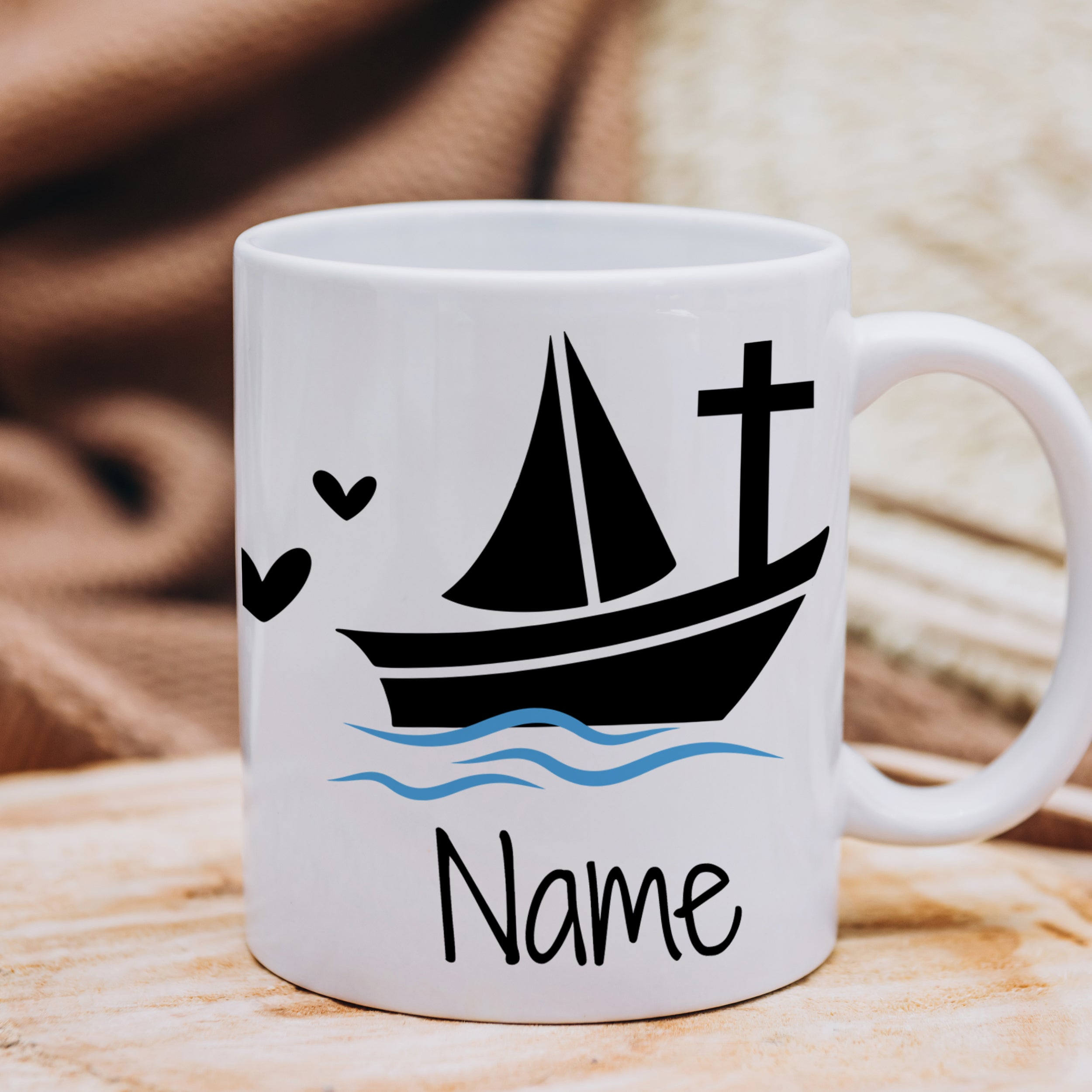 Weißer Becher mit Segelboot, Kreuz und Herzen.