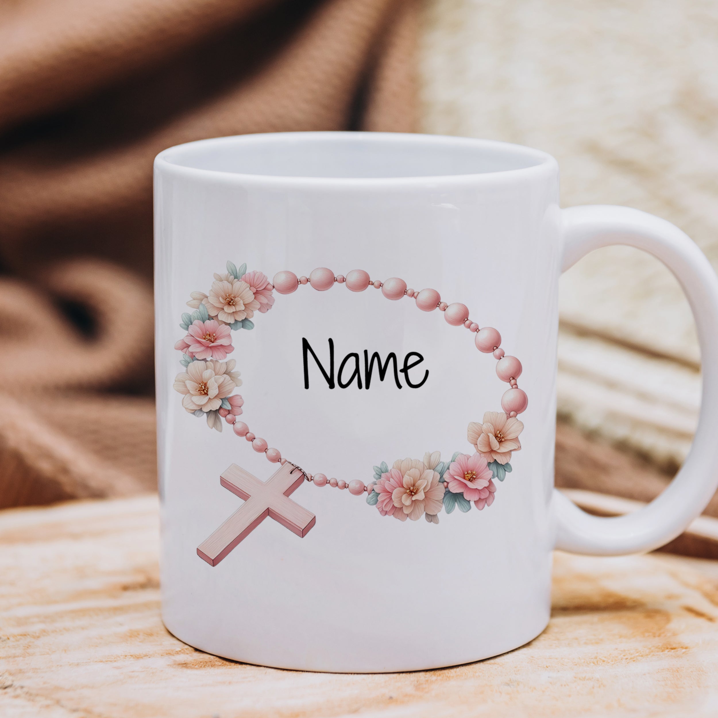 Weißer Becher mit rosafarbenem Kreuz und Blumen.