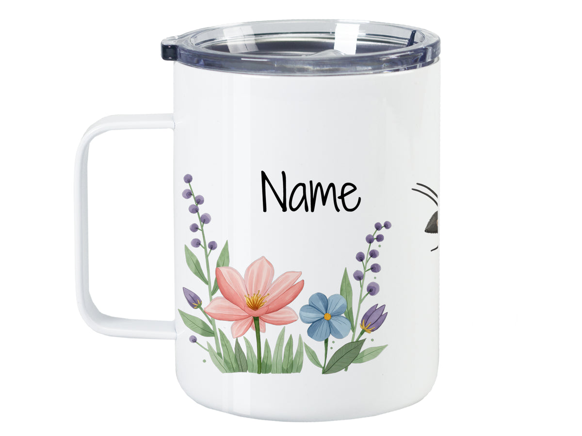 Weißer Becher mit bunten Blumen und personalisiertem Namen.