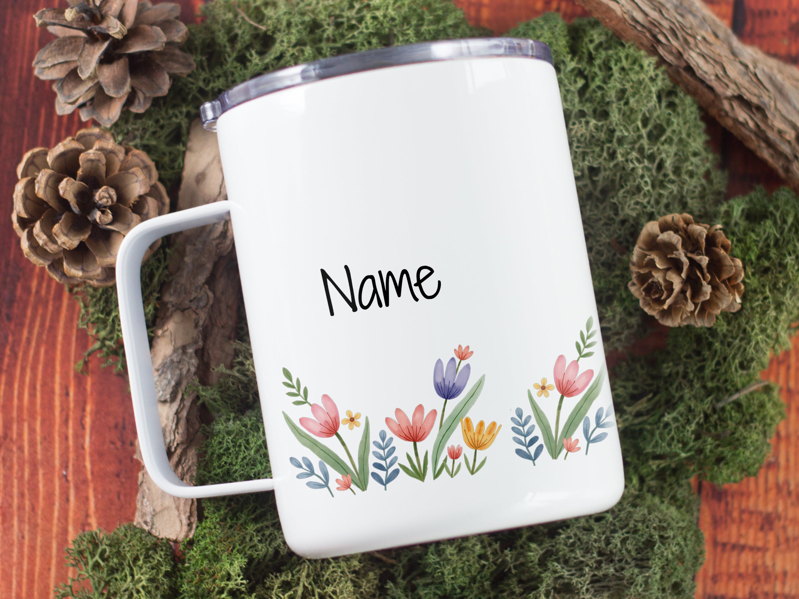 Weißer Becher mit bunten Blumen und personalisierbarem Namen.