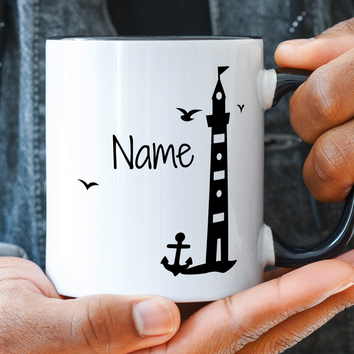 Weiße Tasse mit schwarzem Leuchtturm und Anker.