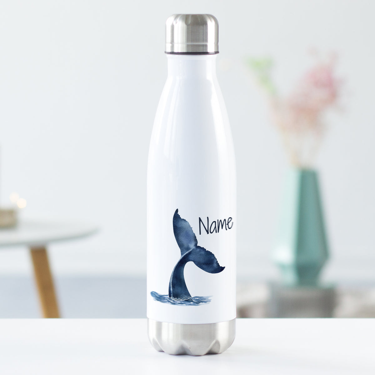 Weiße Edelstahl-Trinkflasche mit blauer Walflosse und Name.