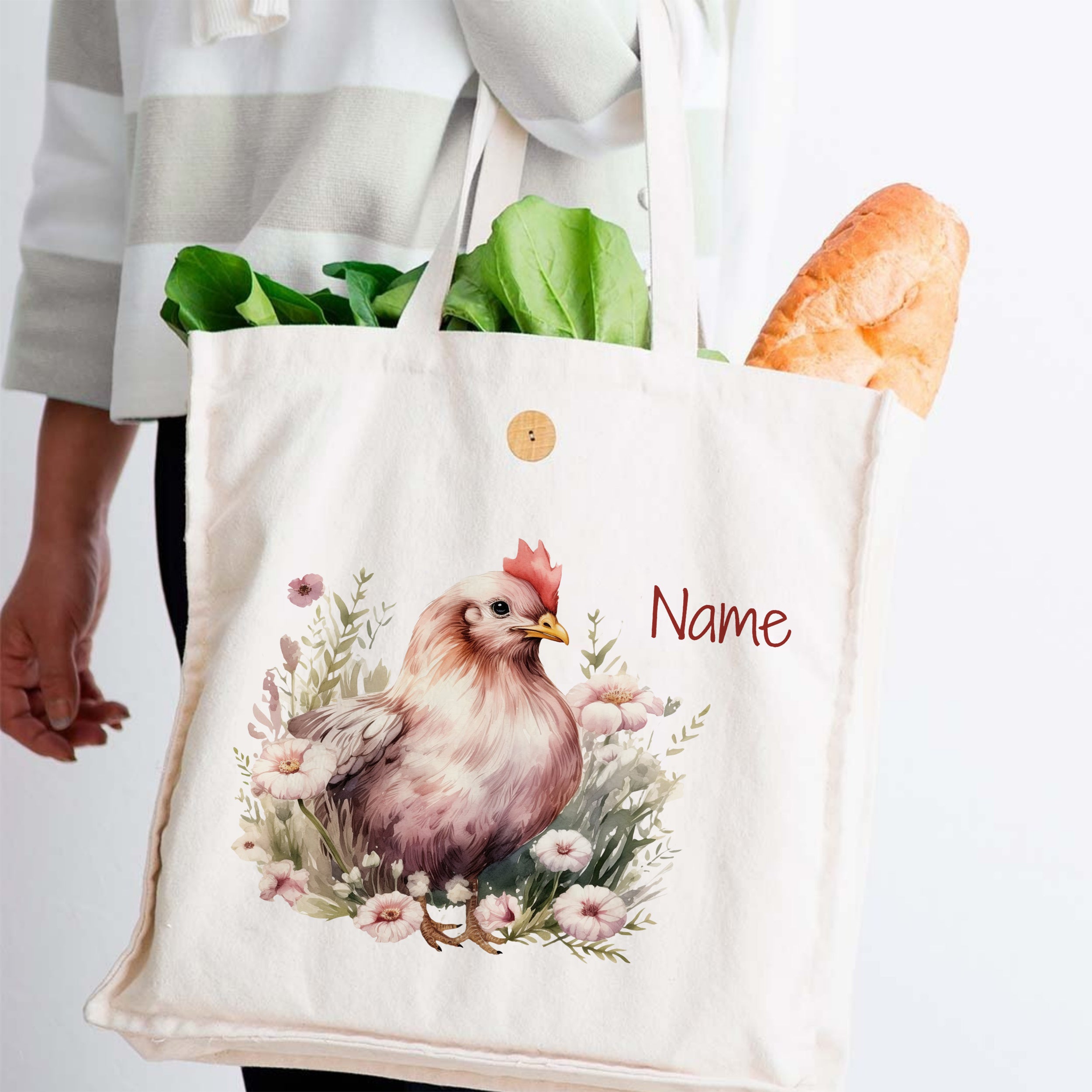Beige Stofftasche mit Huhn-Motiv und grünen Blättern.