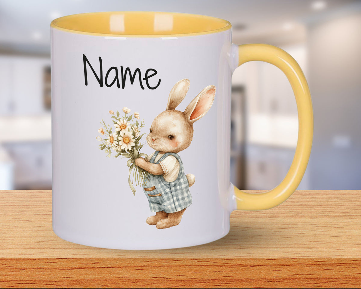 Tasse mit gelbem Henkel, Hase mit Blumenstrauß.