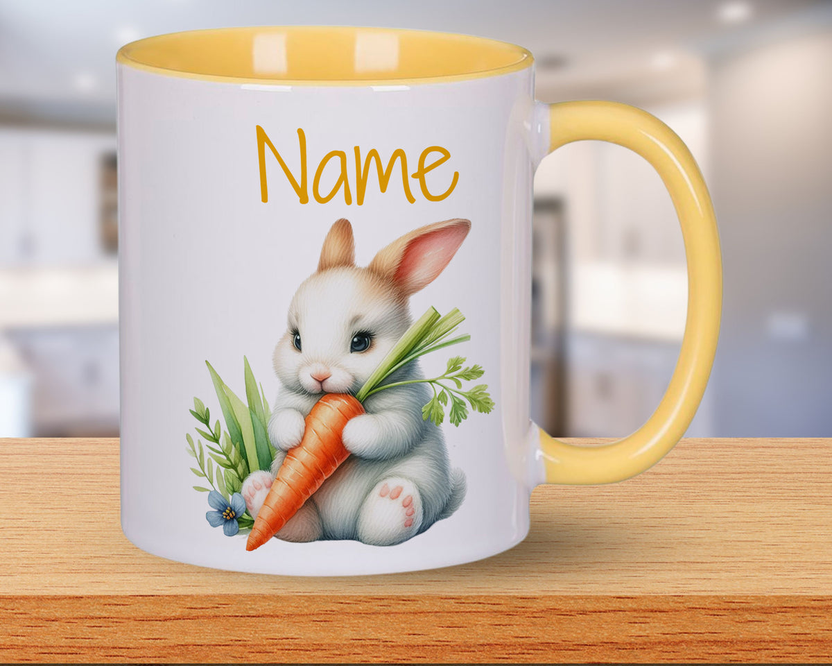 Tasse mit gelbem Henkel, niedlichem Hasen und Karotte.