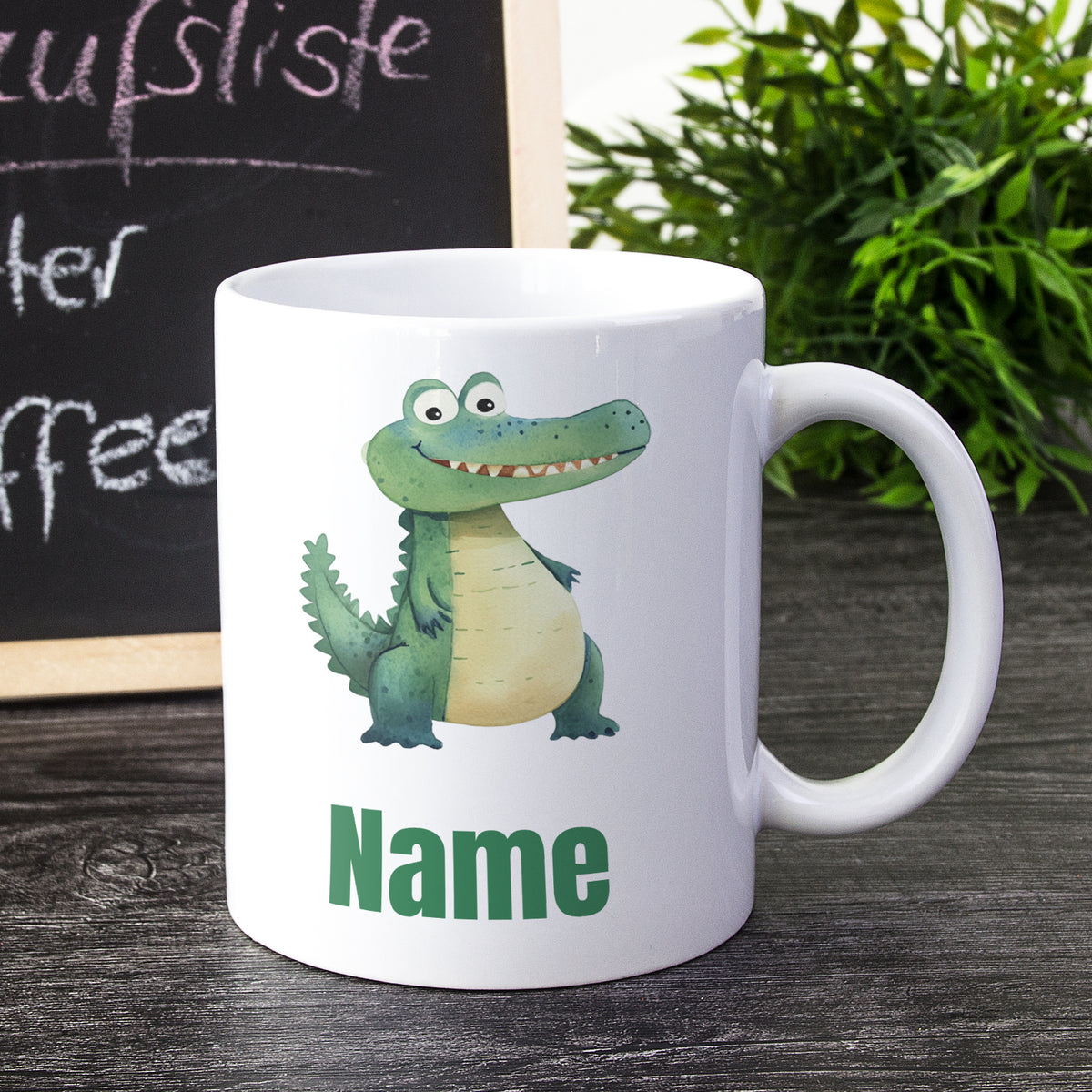 Weißer Kaffeebecher mit Krokodil-Motiv und grünem Text.