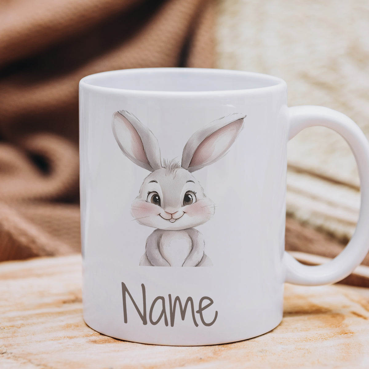 Weißer Becher mit niedlichem Hasenmotiv und Platz für Namen.