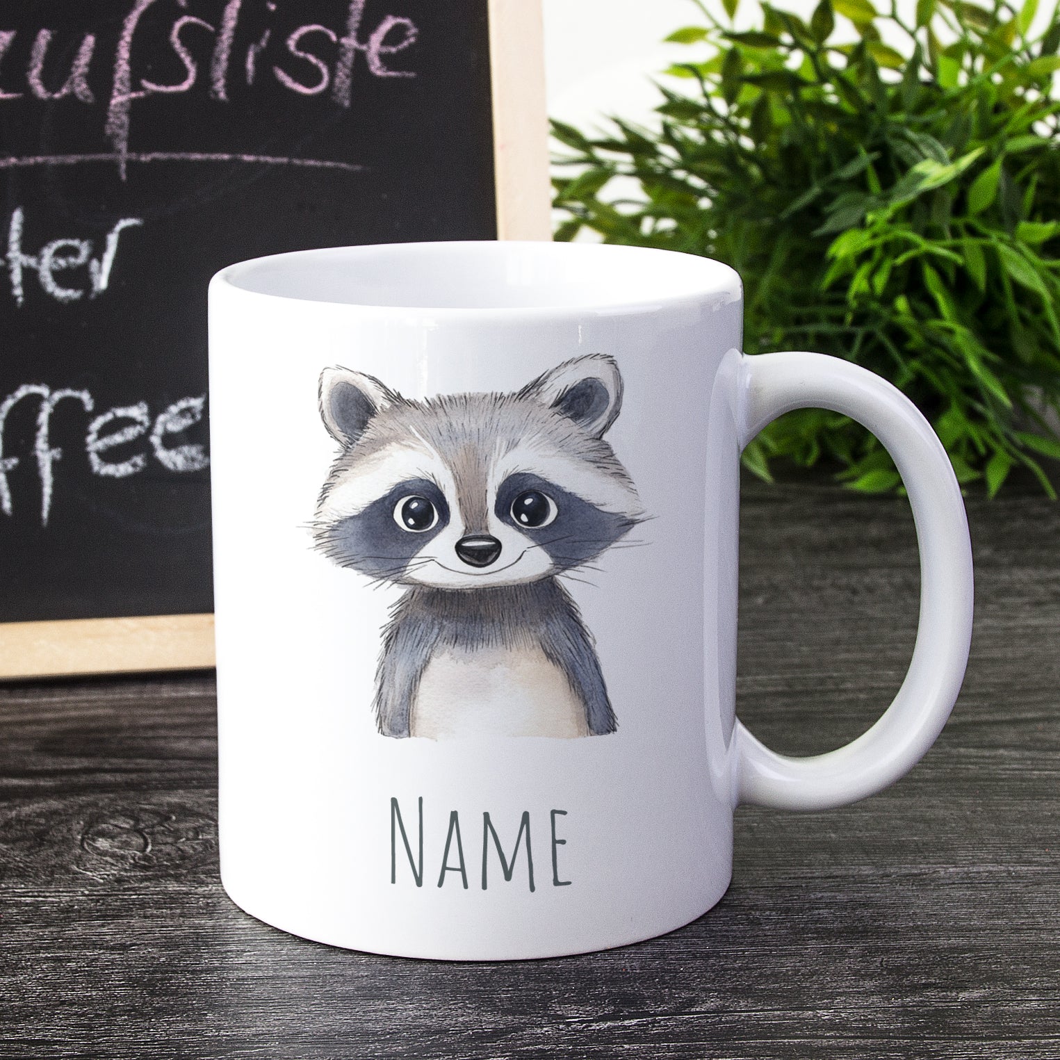 Weißer Becher mit Waschbär-Motiv und Platz für Namen.