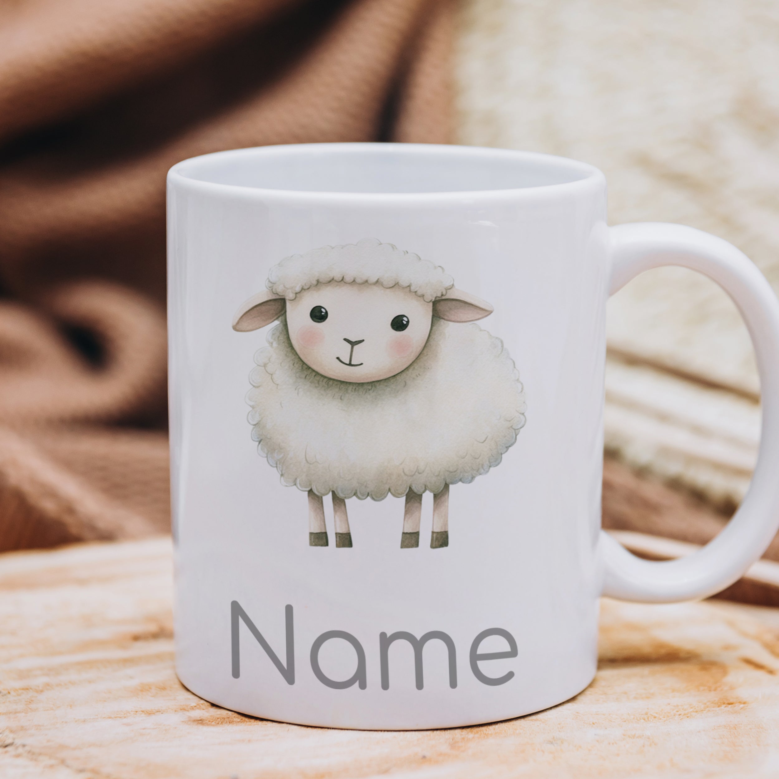 Weiße Tasse mit Schaf-Motiv und Platz für Namen.