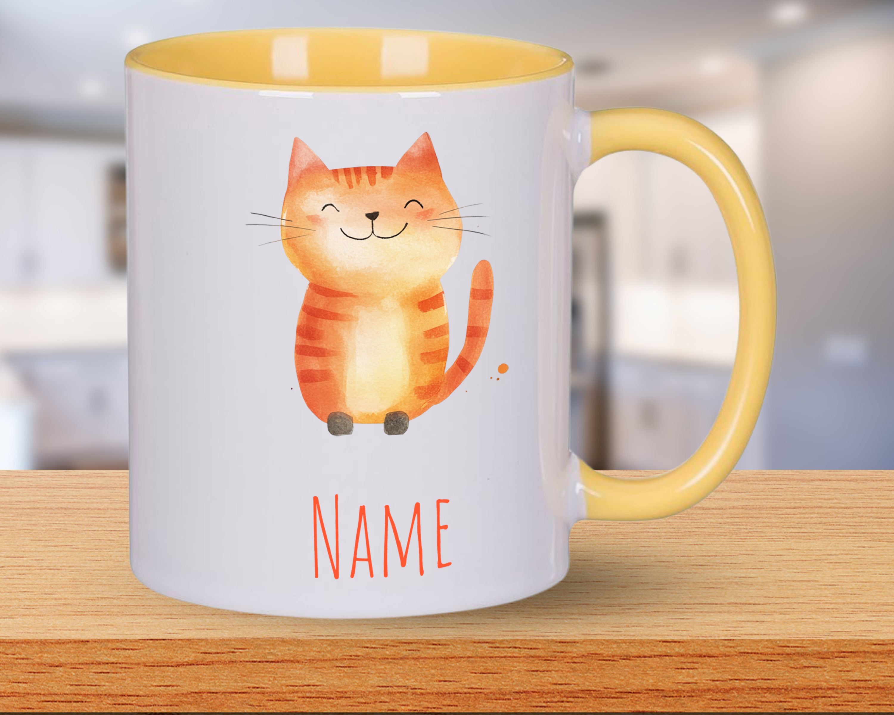 Tasse mit orangefarbenem Katzenmotiv und gelbem Henkel.
