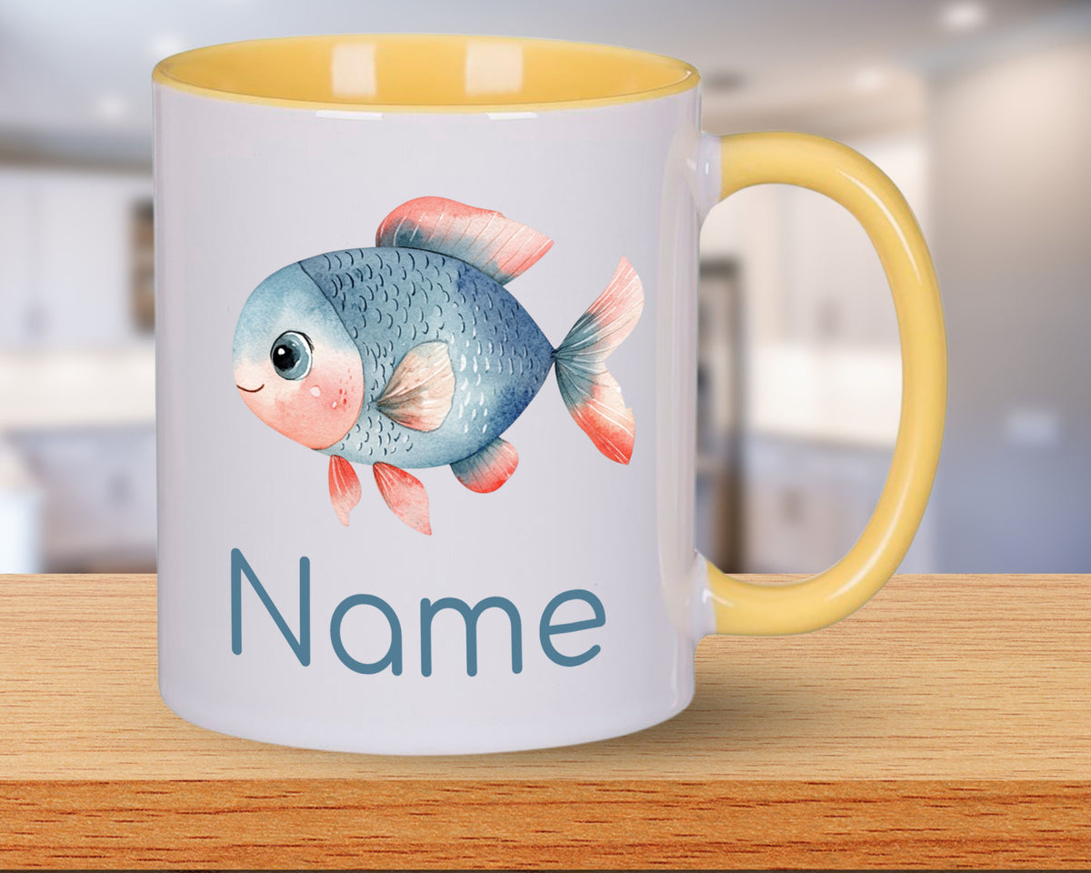 Tasse mit blauer Fischillustration und gelbem Henkel.