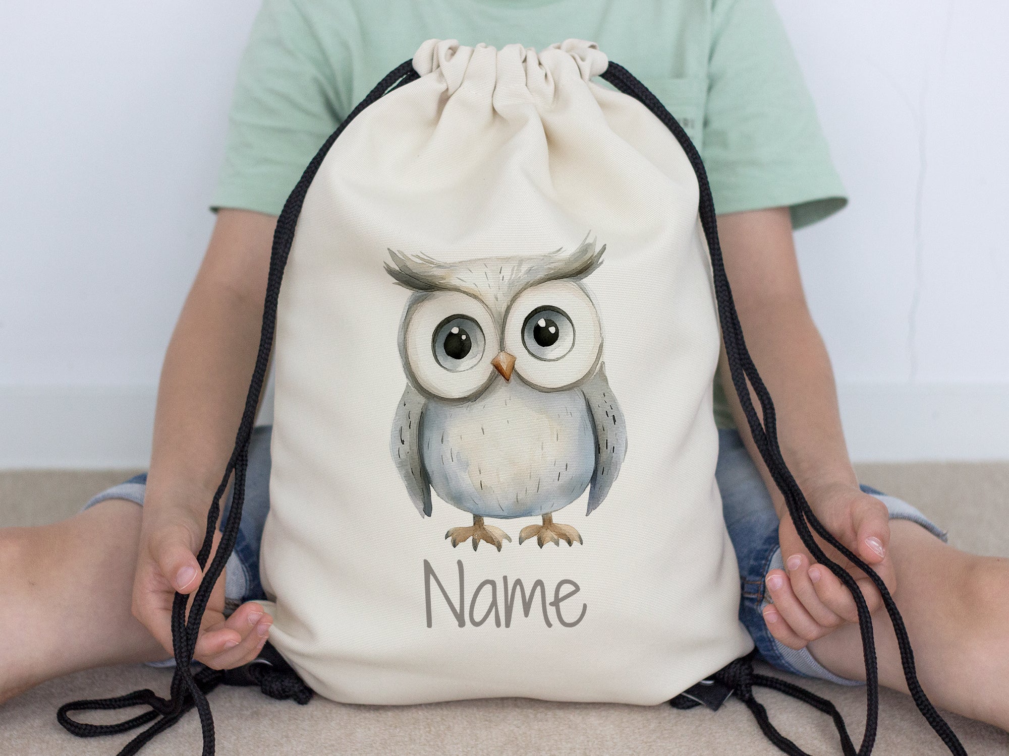 Beige Turnbeutel mit Eule und personalisierbarem Namen.