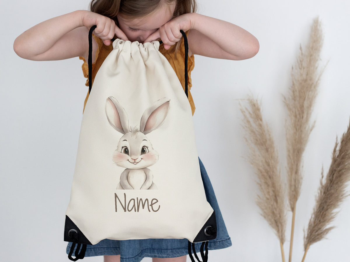 Beige Rucksack mit niedlichem Hasenmotiv und Platz für Namen.