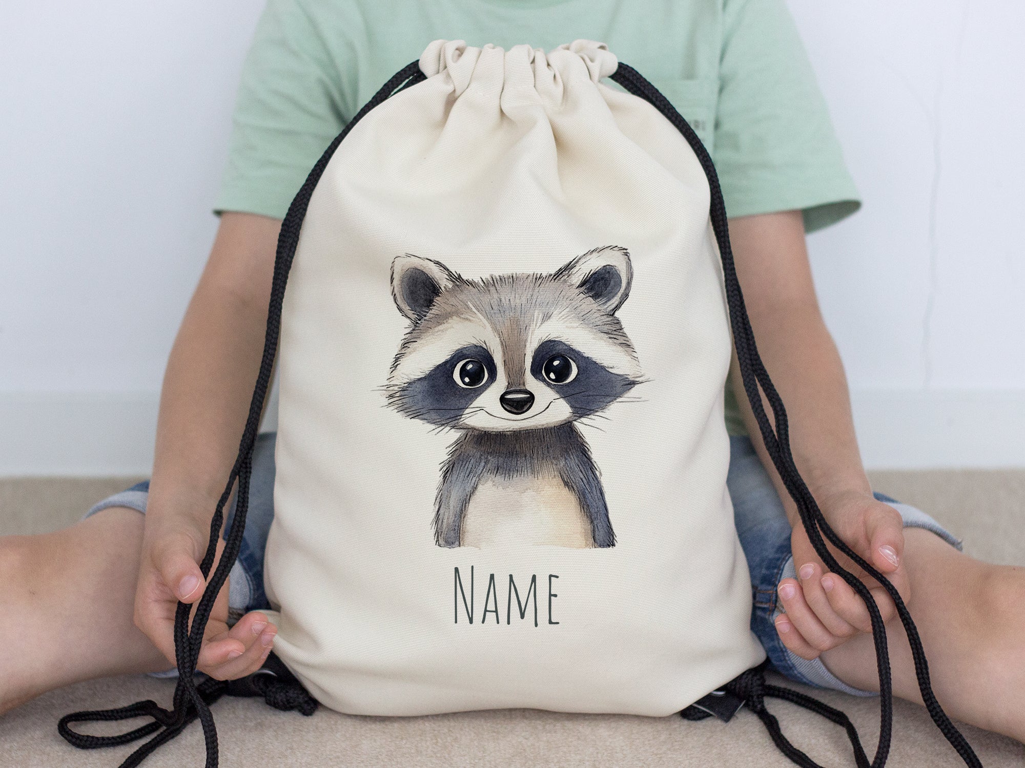 Beige Rucksack mit niedlichem Waschbären-Motiv und Platz für Namen.