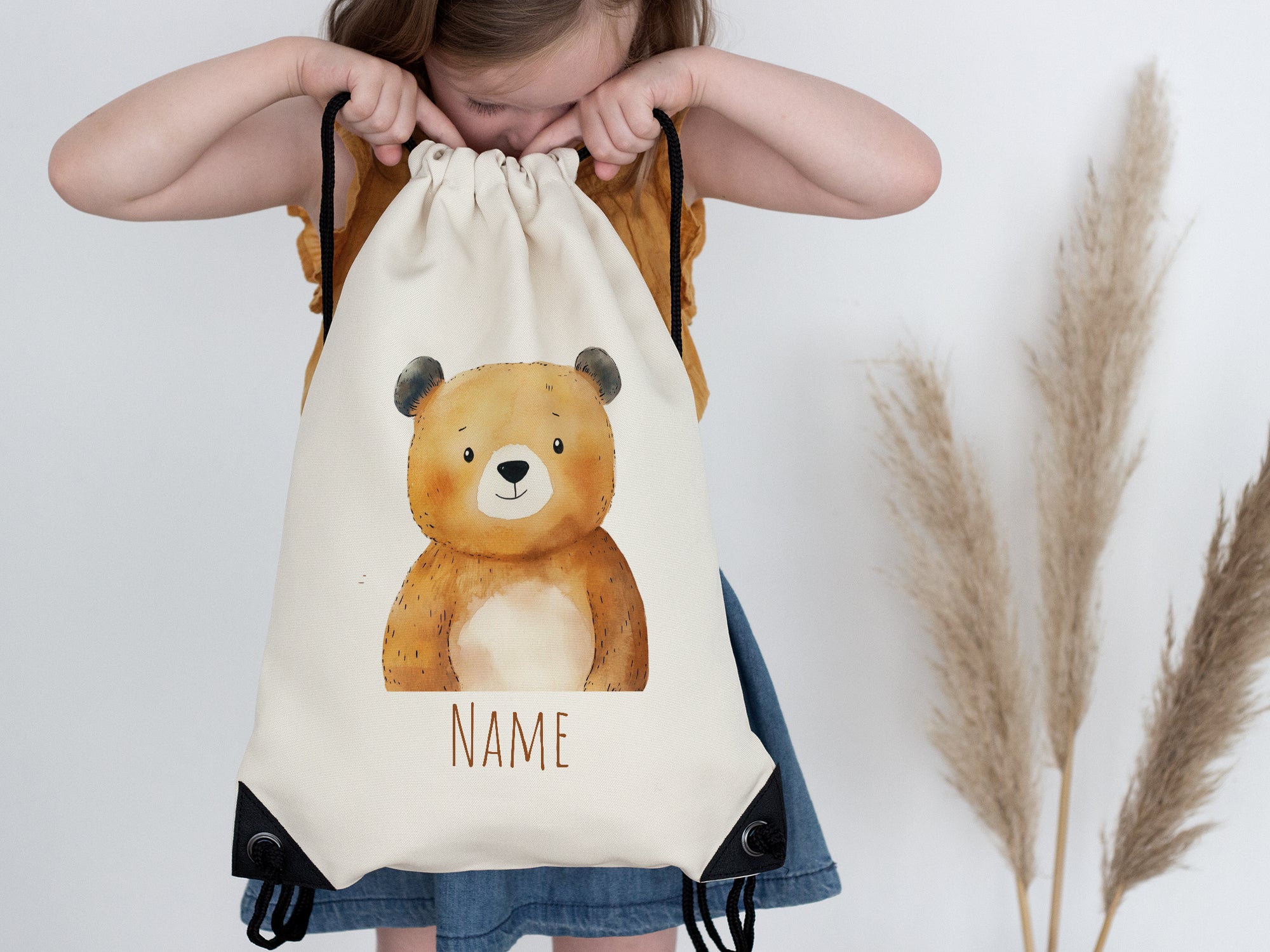 Beige Rucksack mit Bärenmotiv und personalisierbarem Namen.
