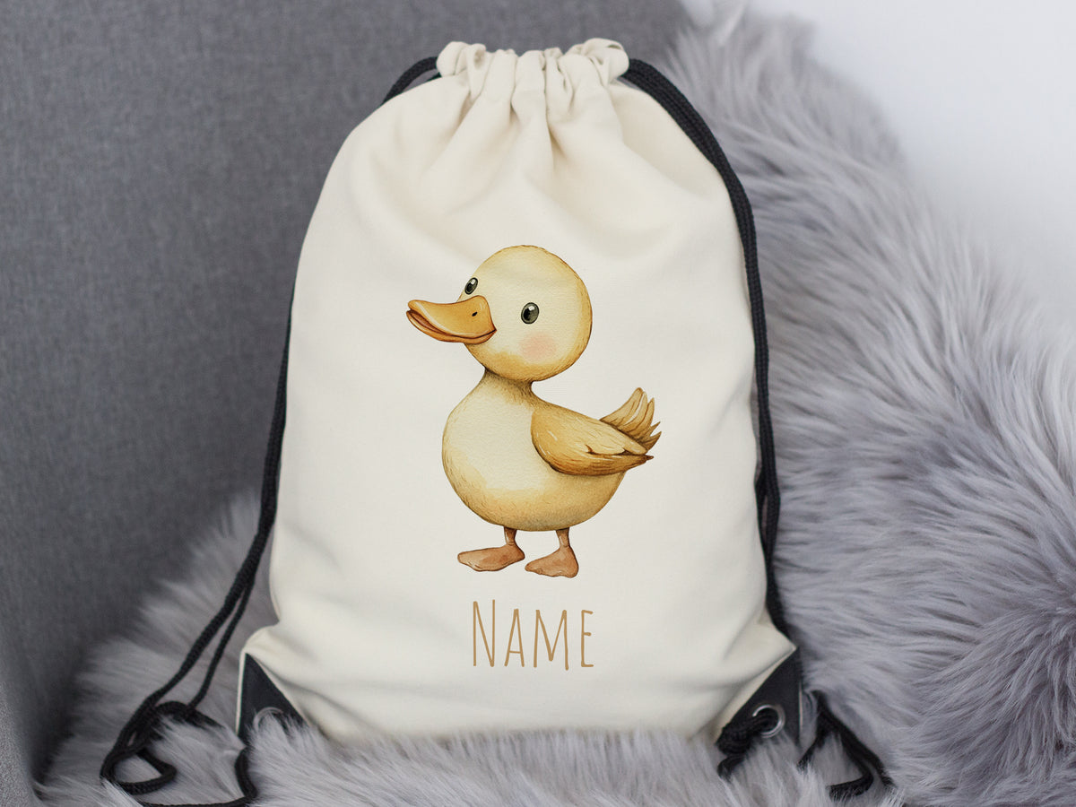 Beige Rucksack mit Entenmotiv und personalisierbarem Namen.