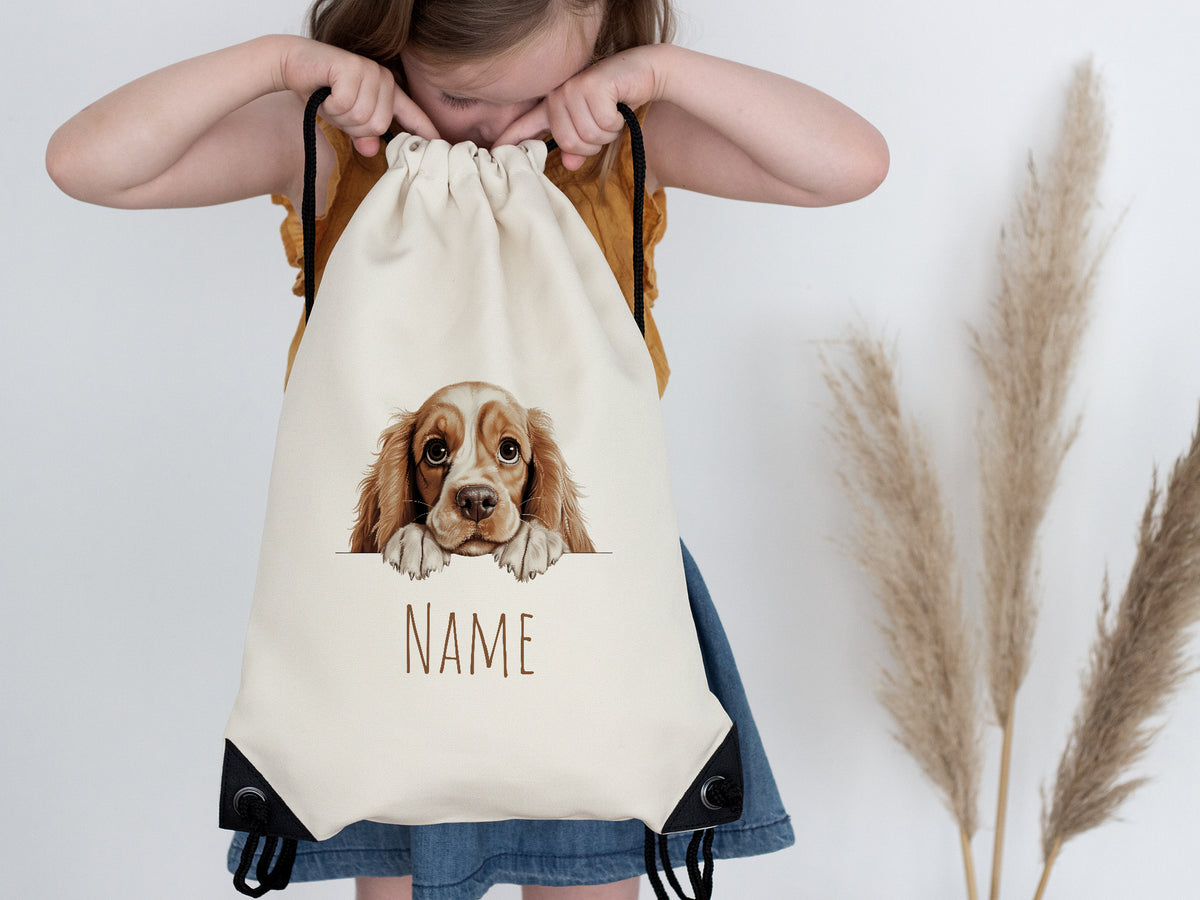 Beige Rucksack mit Hundemotiv und personalisierbarem Namen.