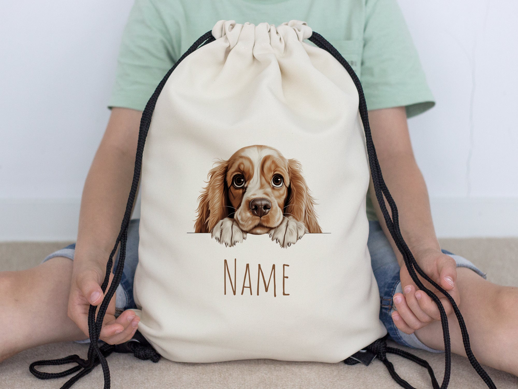 Beige Rucksack mit Hundemotiv und personalisierbarem Namen.