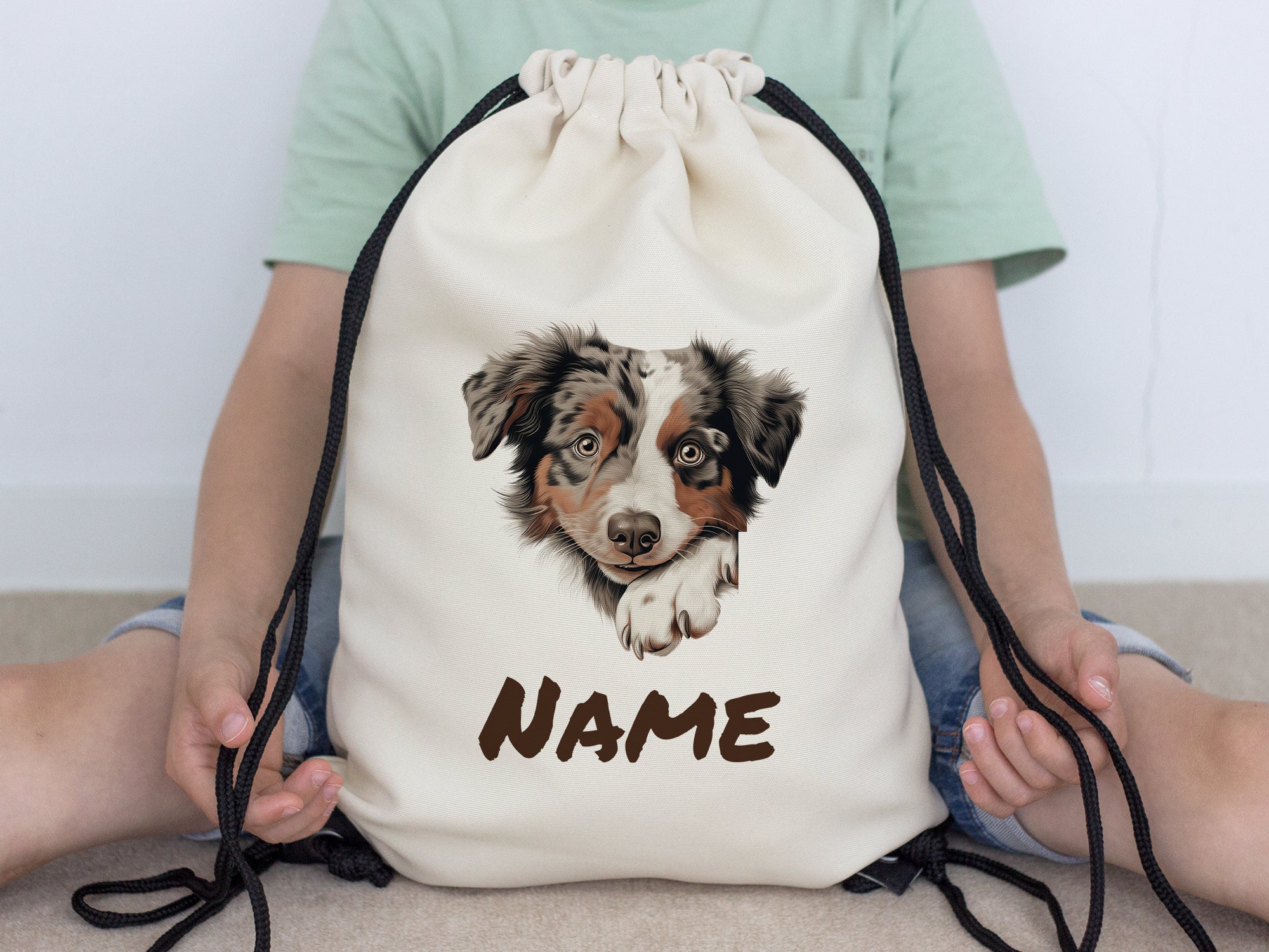 Beige Turnbeutel mit Hundemotiv und personalisiertem Namen.